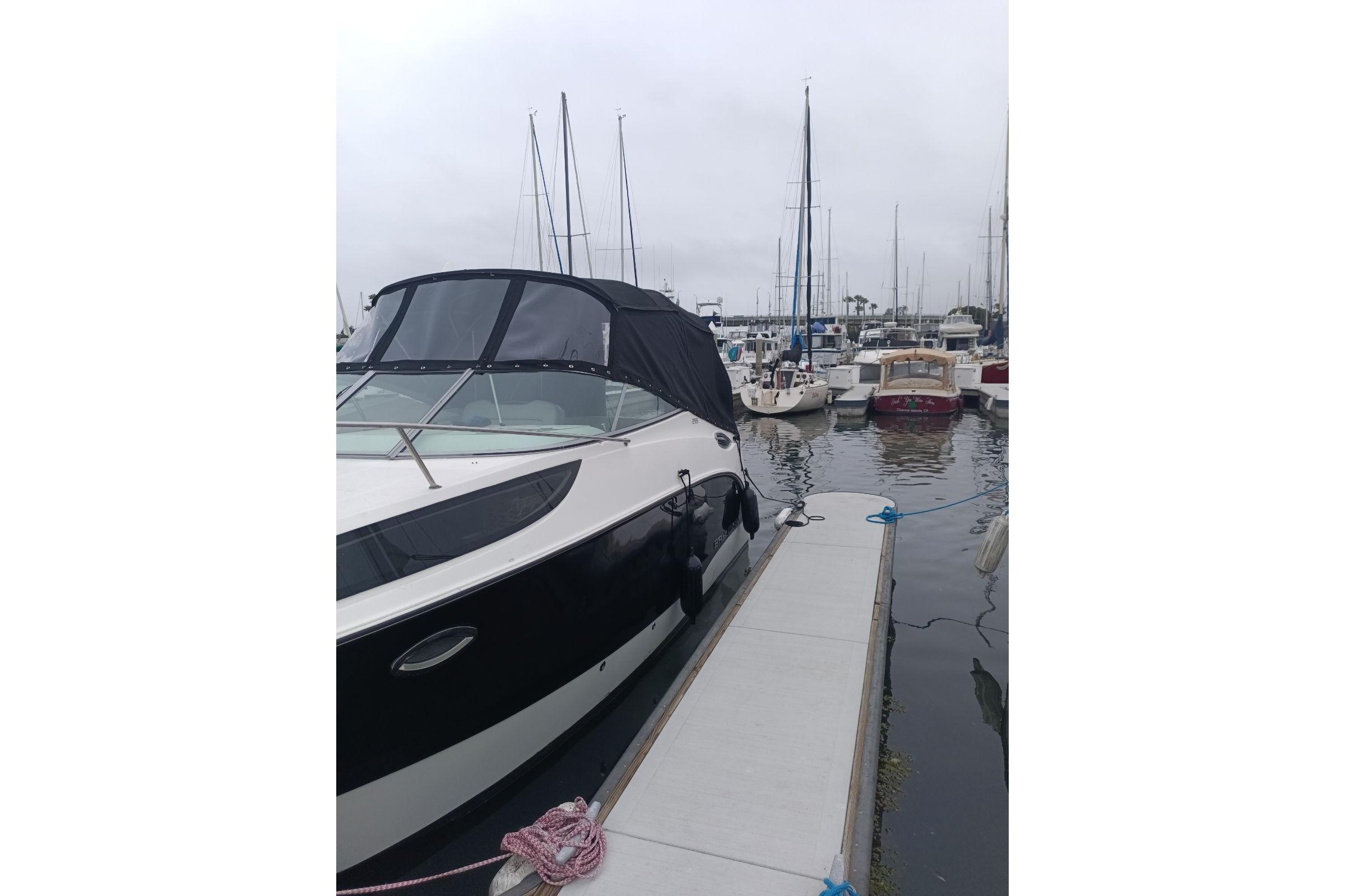 Bayliner 255 Cruiser 2010 docked at marina with other boats in background.