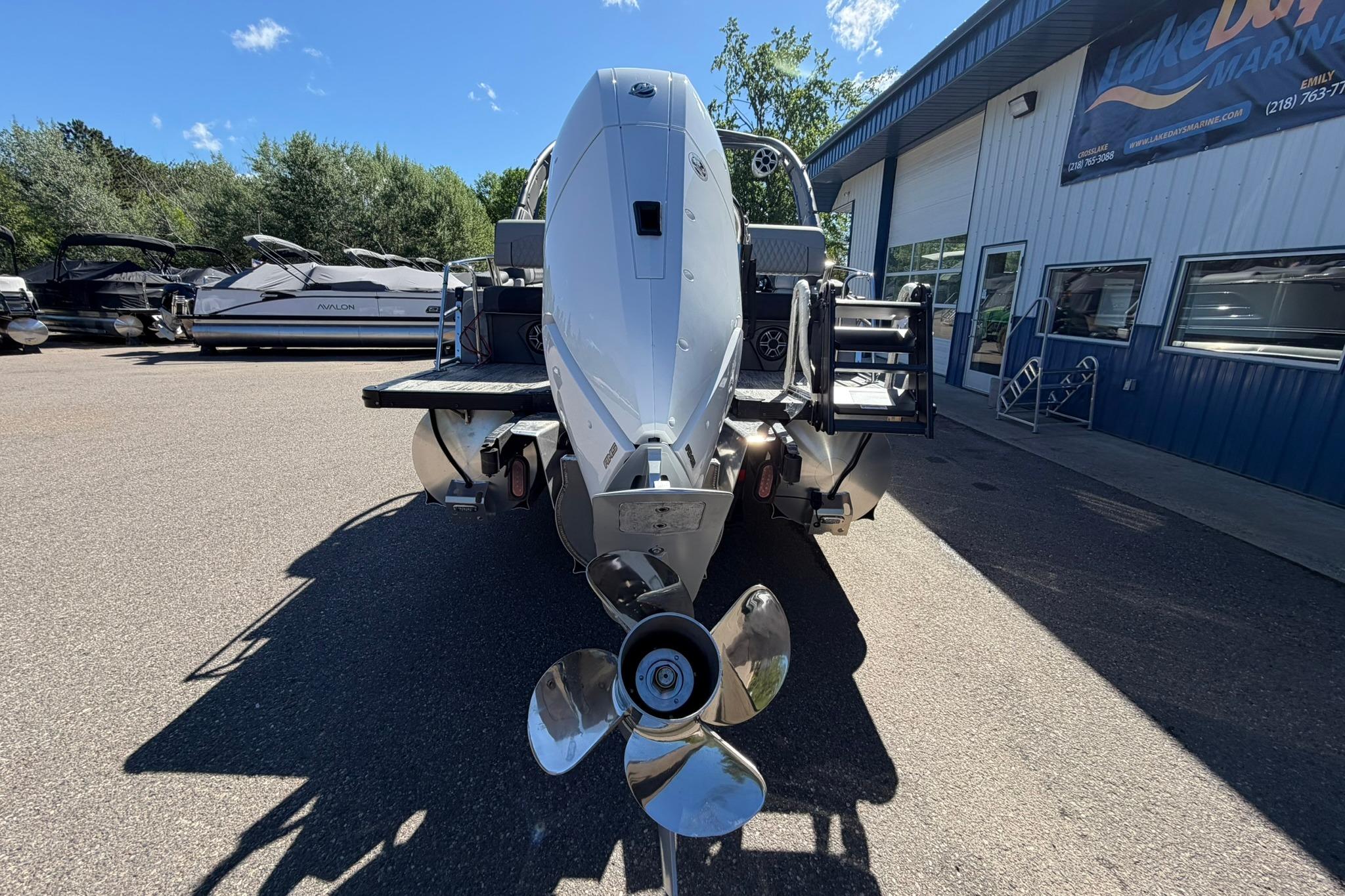 2026 Avalon Excalibur LTD Quad Lounge boat at marina, rear view with propeller.
