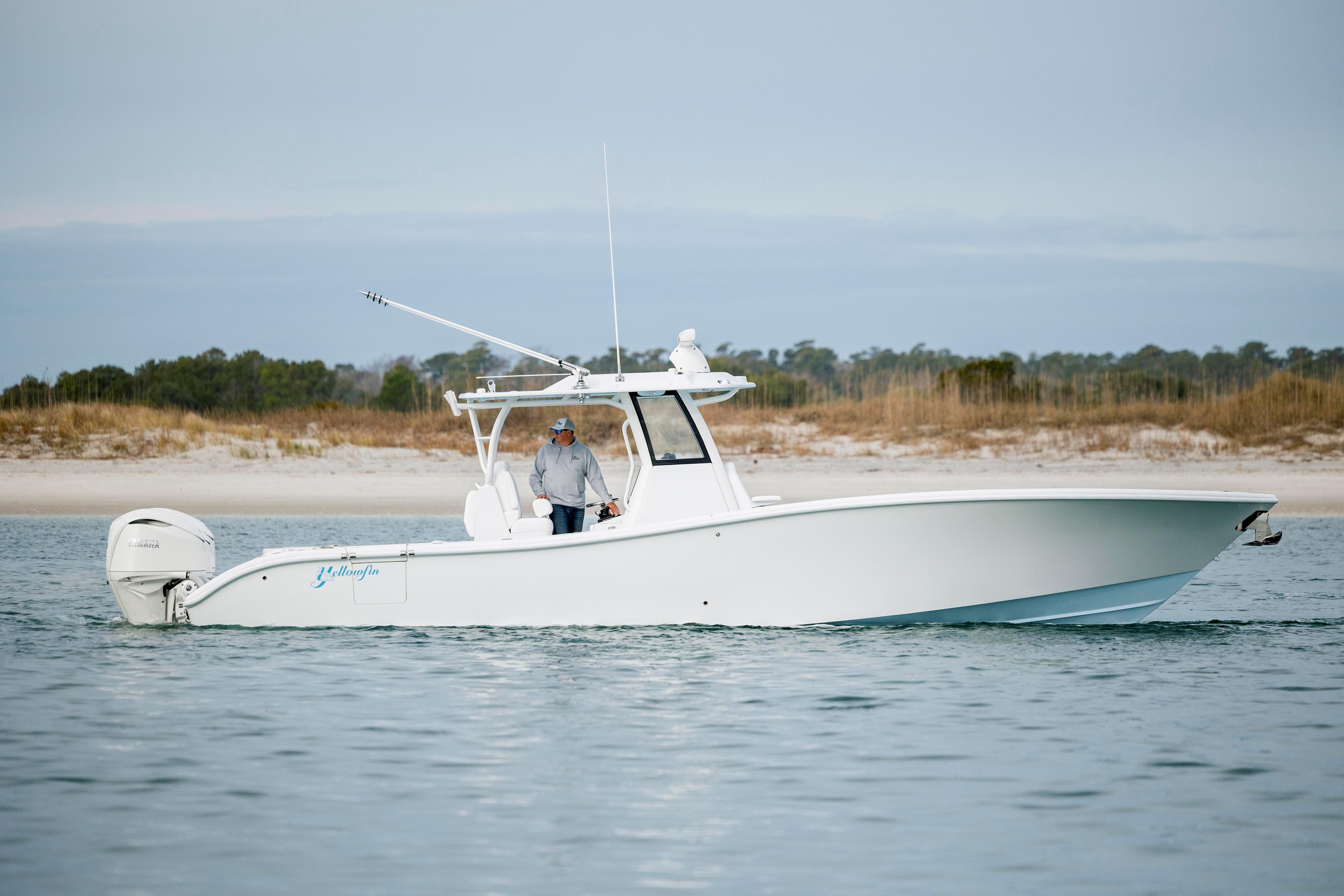 2026 Yellowfin 36 Offshore boat on calm water near sandy shoreline.