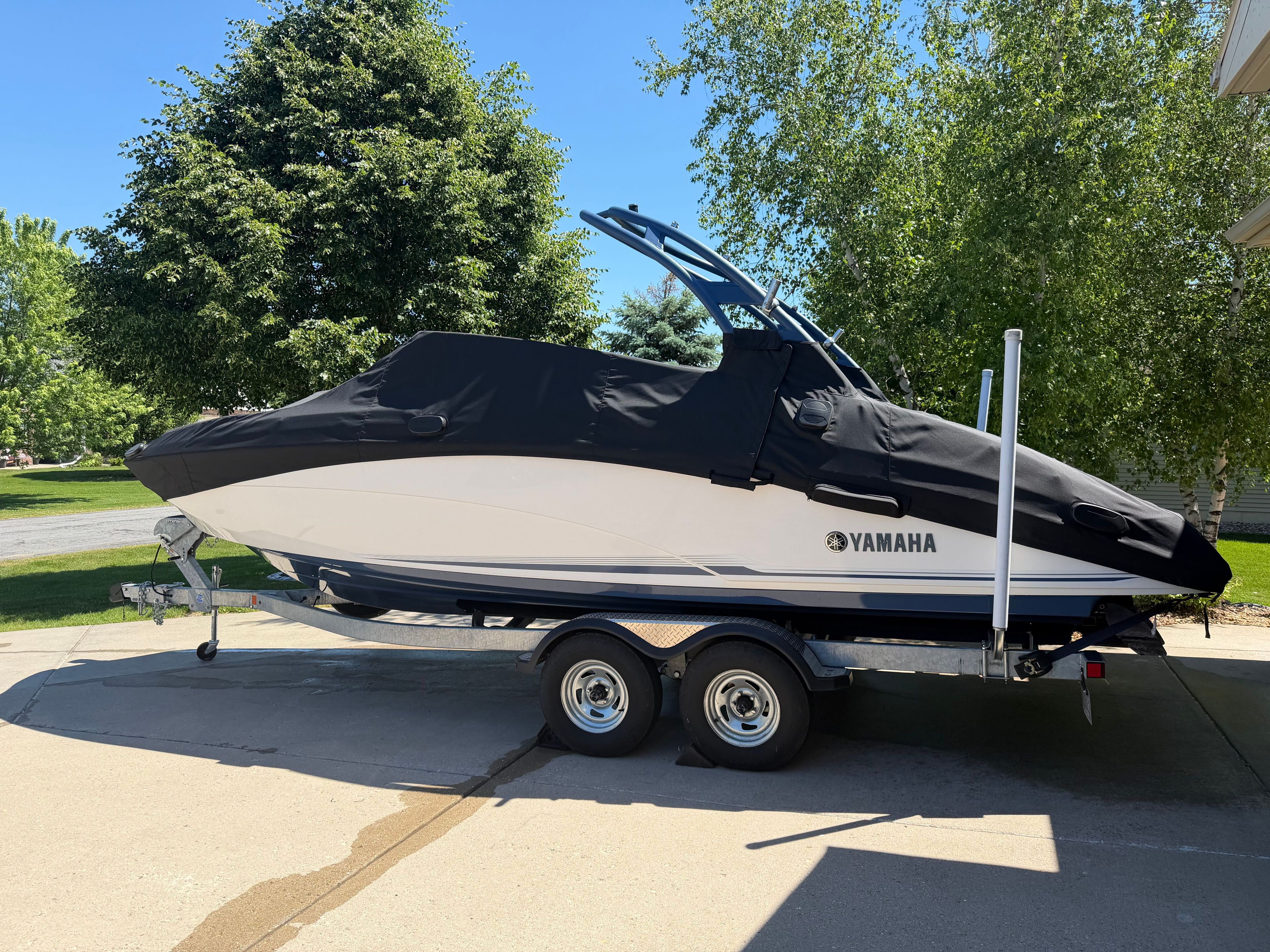 A 2018 Yamaha 242 Limited S boat on a trailer, covered and ready for transport.
