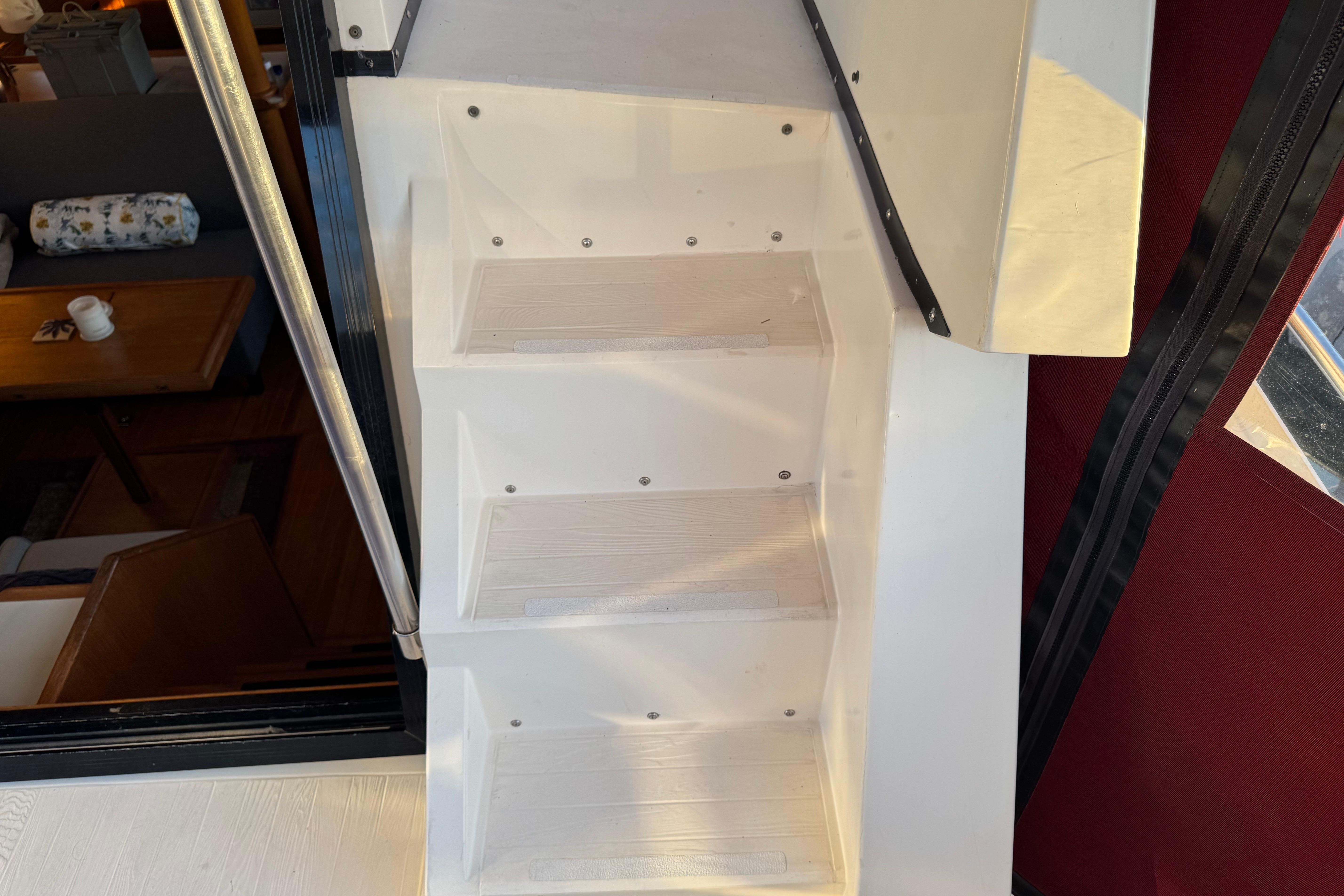 White stairs inside a 1987 President 37 yacht, with a cozy interior view.