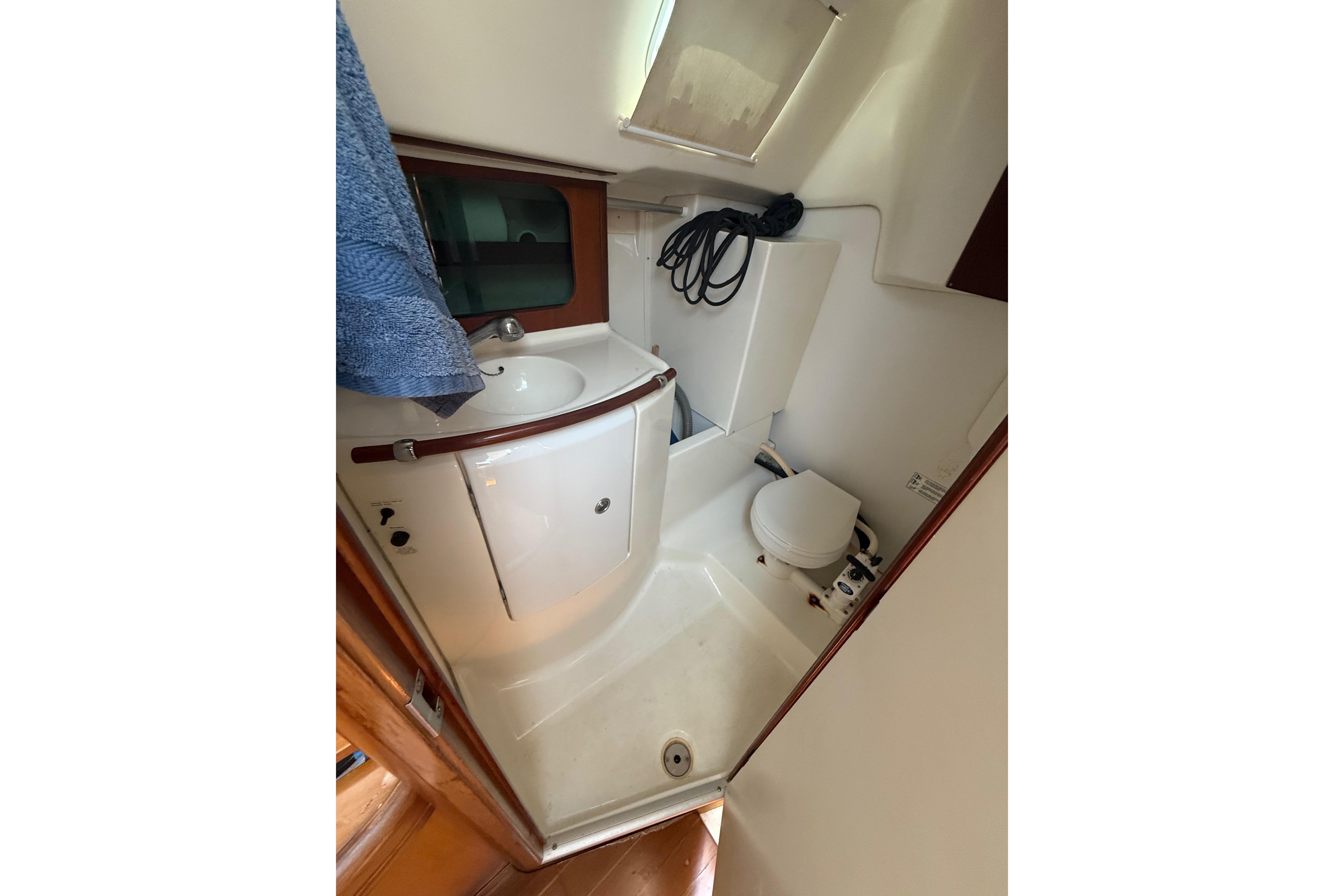 Bathroom interior of 2002 Beneteau Oceanis Clipper 311 yacht, featuring sink and toilet.