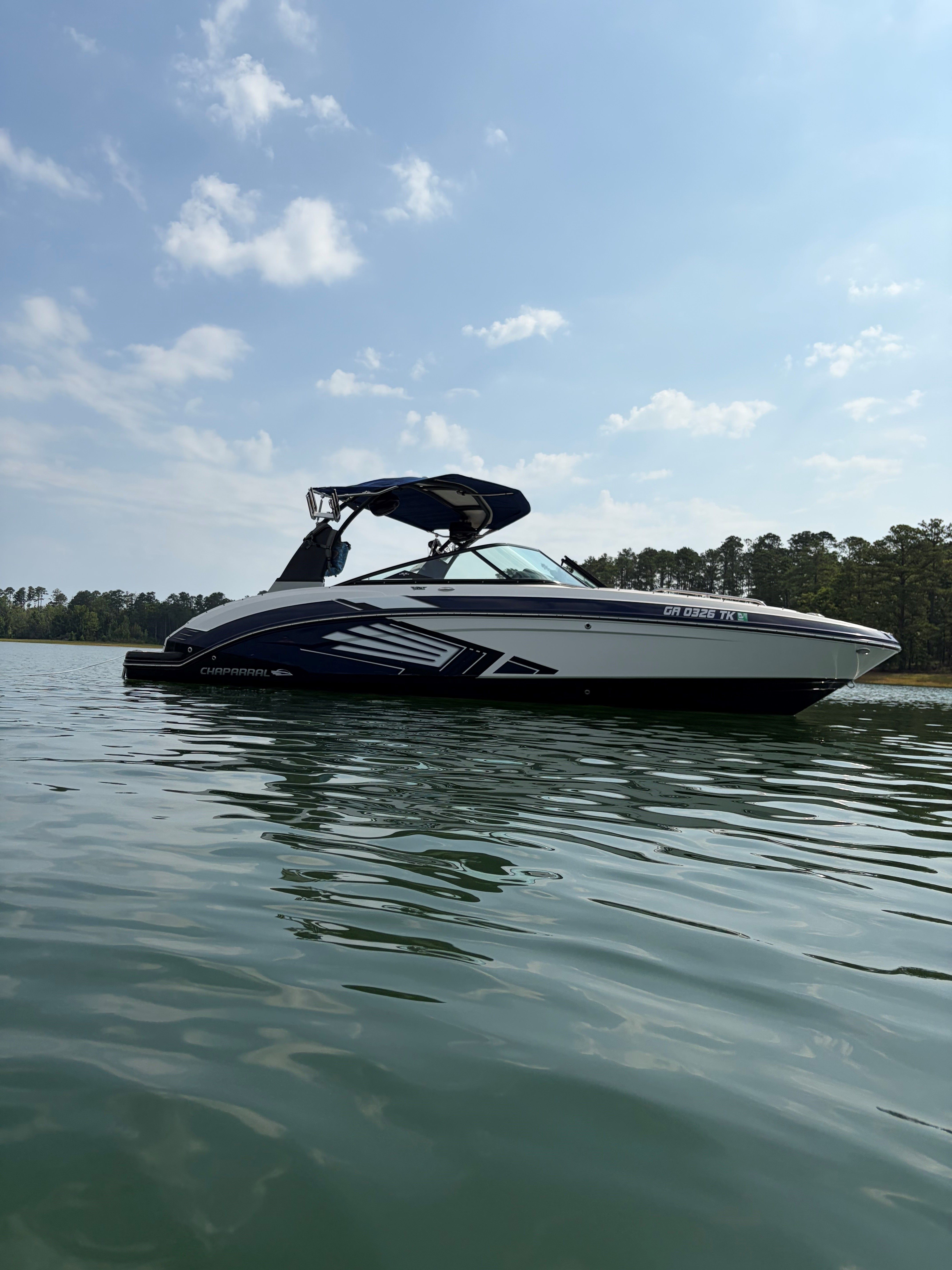 A 2015 Chaparral Vortex 243 VRX floats on calm water under a cloudy sky.