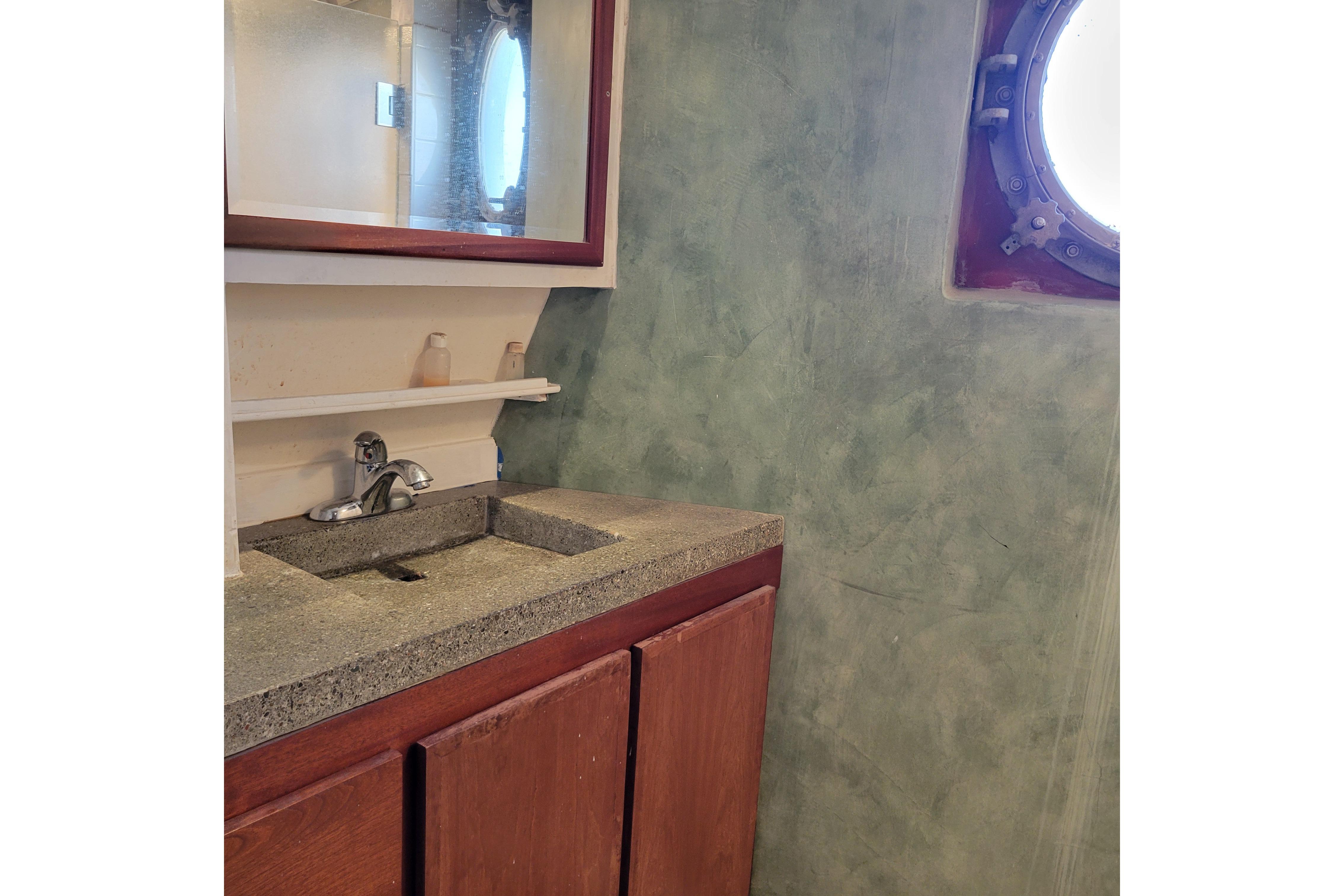 Bathroom sink area in a 1979 Shrimper Conversion Trawler with porthole window.
