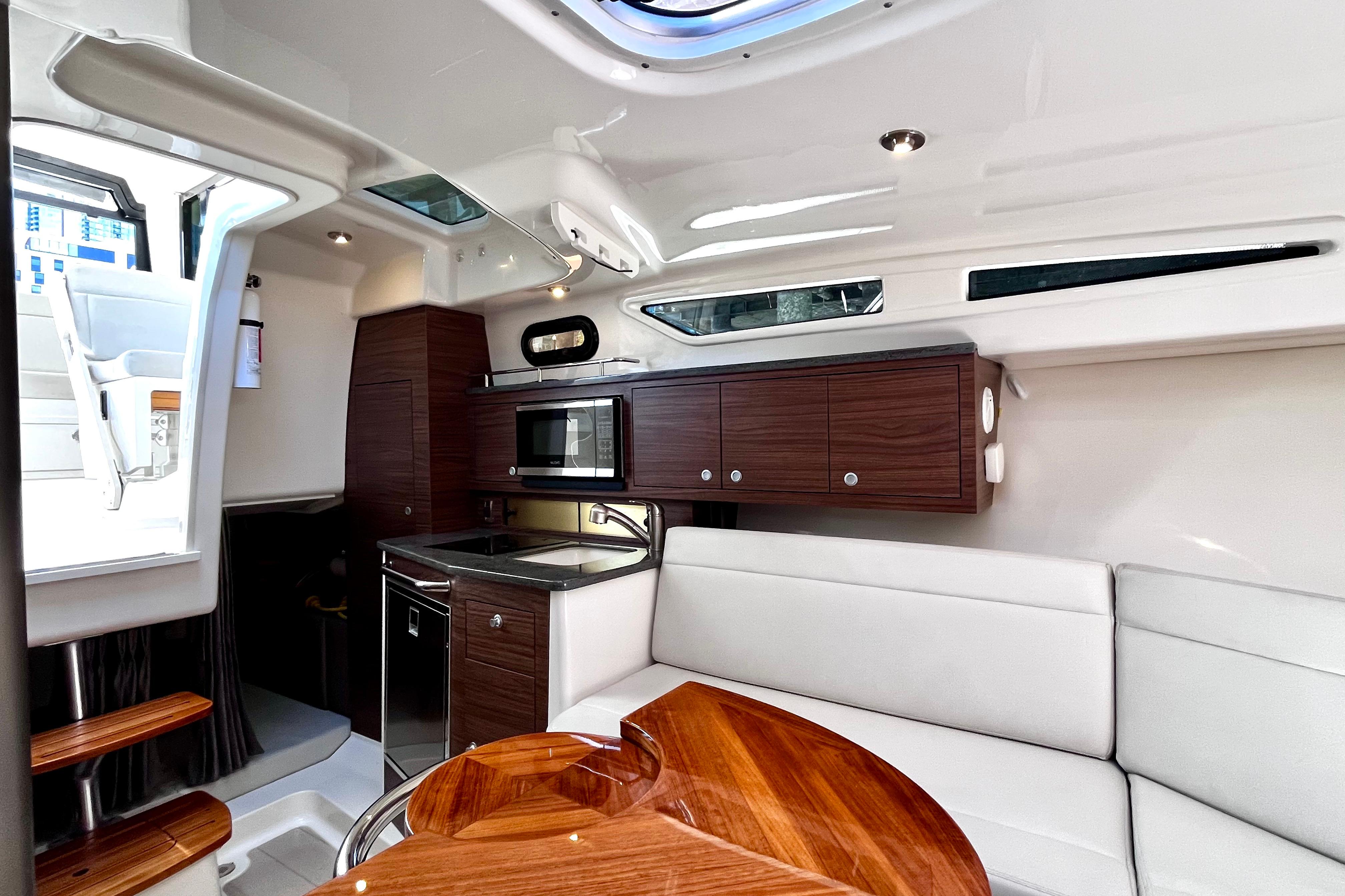 Luxurious interior of 2026 Boston Whaler 325 Conquest Pilothouse with modern kitchen amenities.