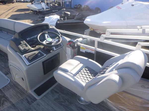 2024 Ranger Reata 223C boat interior with steering wheel and cushioned seating.