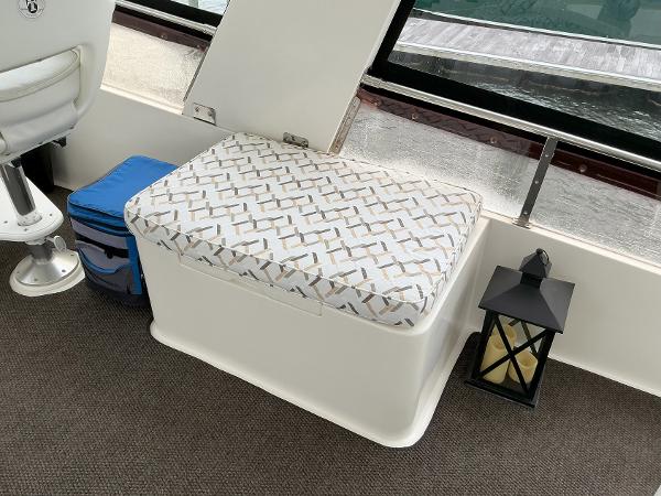 Cushioned seating area on 2000 Novatec Islander 55 yacht interior with lantern and cooler.