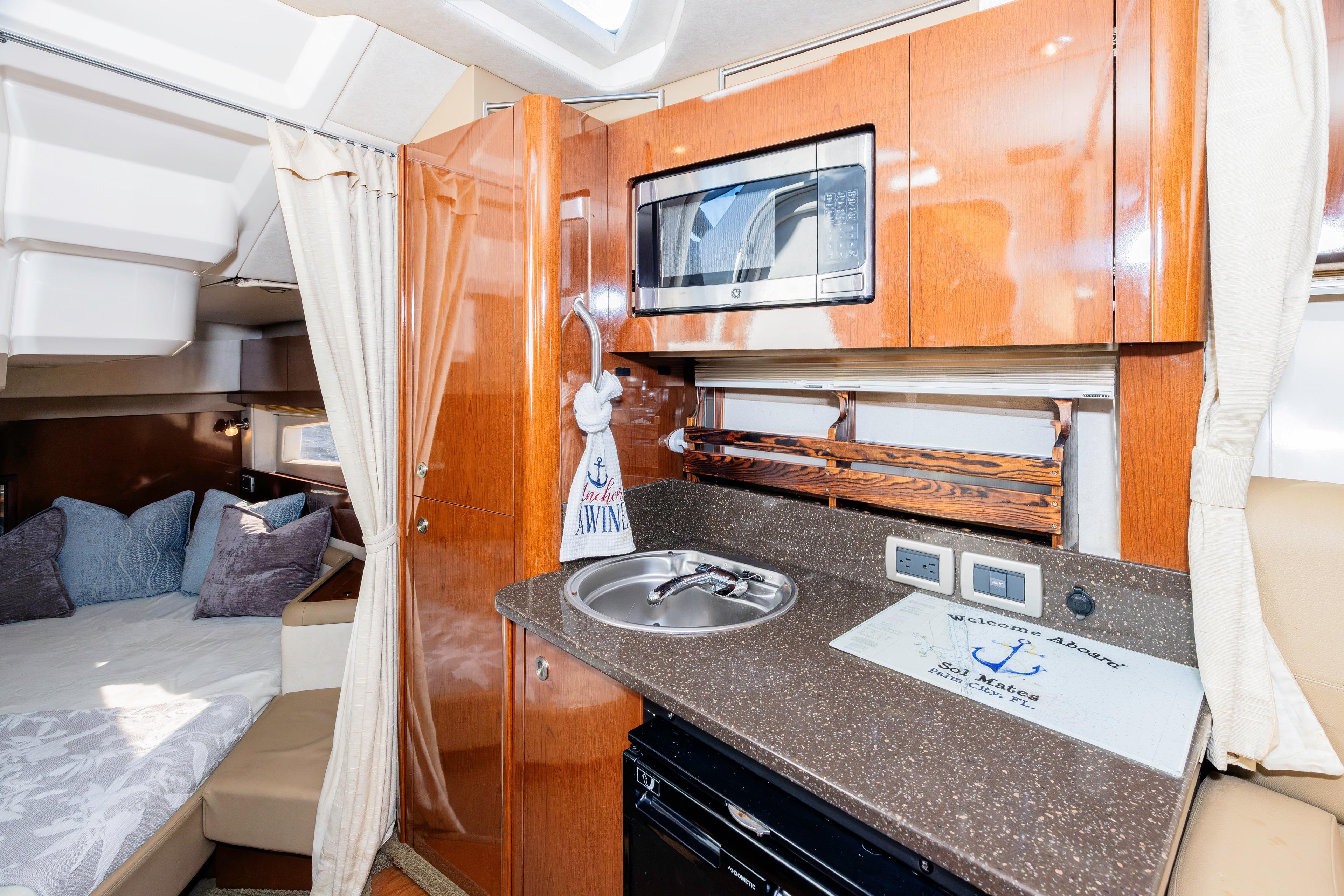 2013 Sea Ray 370 Venture interior with kitchenette and cozy sleeping area.
