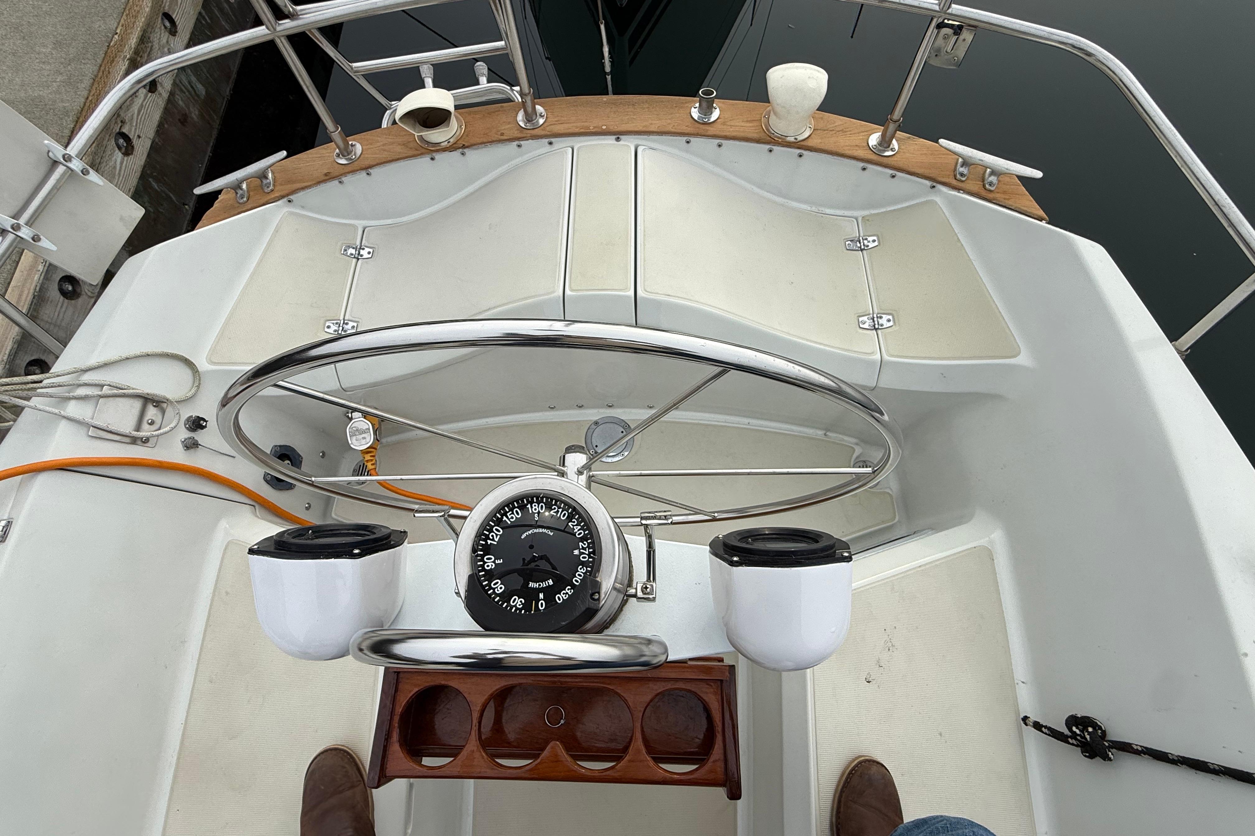 Cockpit of 1988 Ericson 32-200 sailboat with steering wheel and compass.