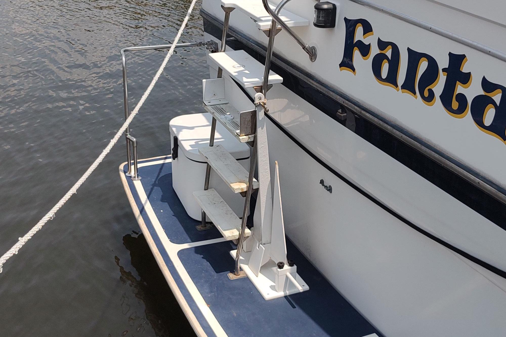 1989 Hyatt Double Cabin Motoryacht stern with steps and railing on water.