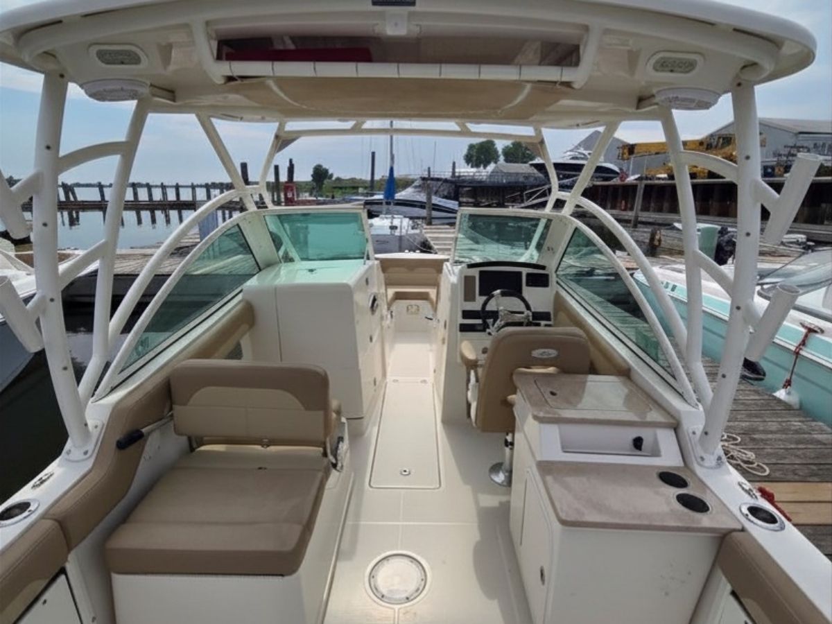 The image shows the cockpit of a 2020 Sailfish 245 DC with beige seating and helm.