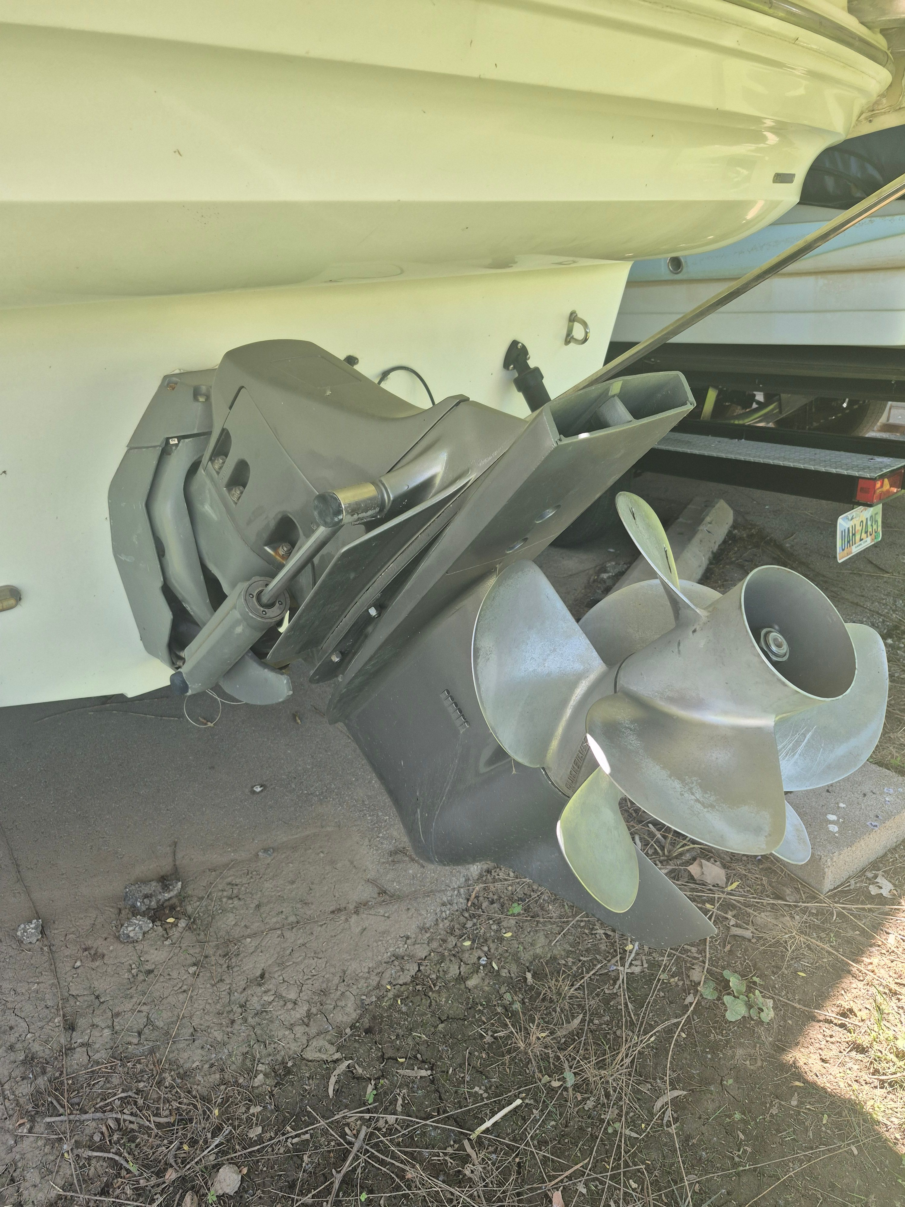 Close-up of a boat motor with propeller, partially on a trailer.