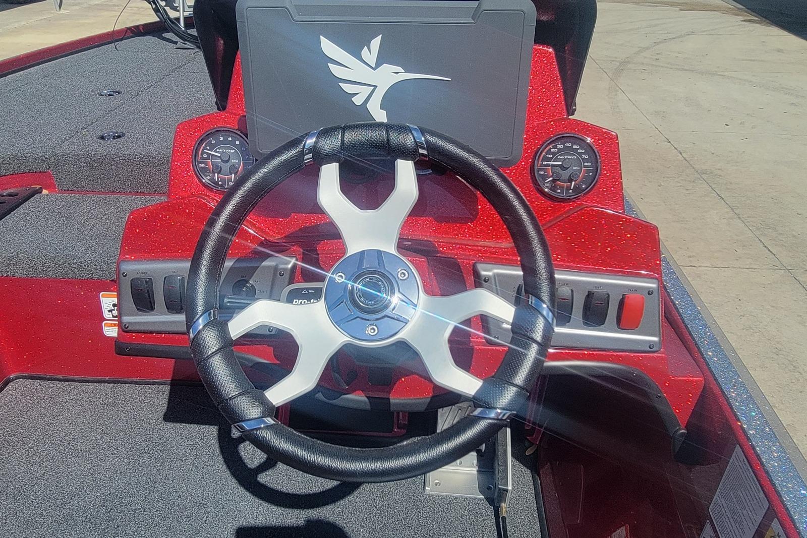 Steering wheel of a 2026 Nitro Z18 boat with red dashboard and gauges.