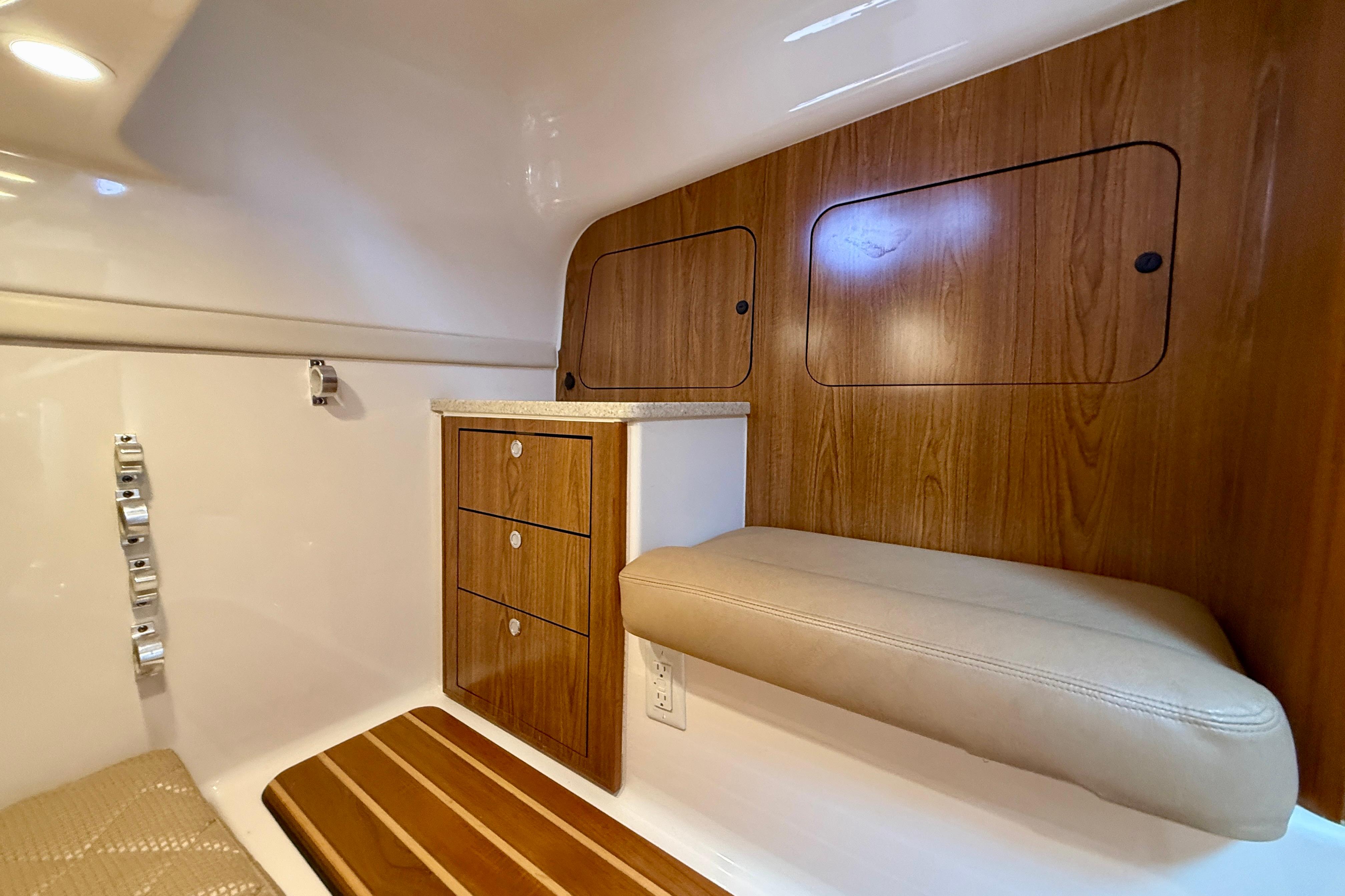 Interior of 2012 Pursuit OS 345 Offshore boat with wood cabinetry and cushioned seating.