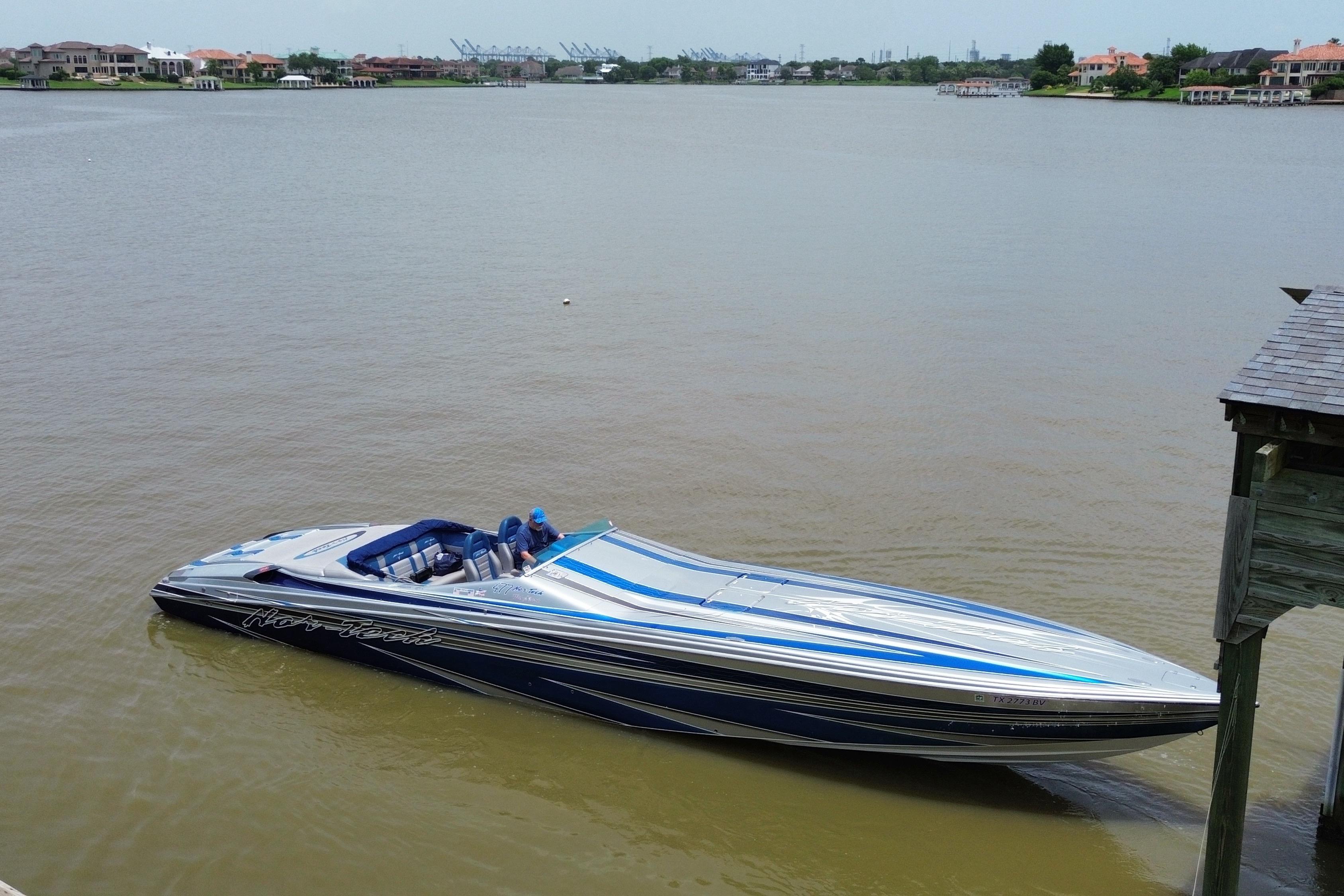 2013 Nor-Tech 477 SPX Vee Bottom boat on calm waters near a dock.