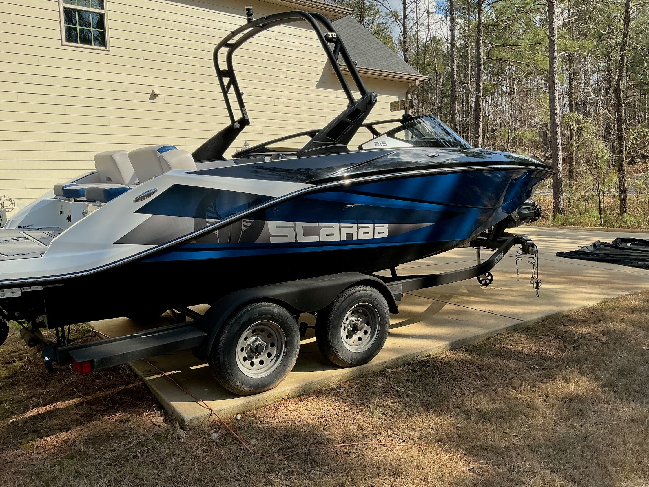 2021 Scarab 215 ID boat parked on trailer outdoors.