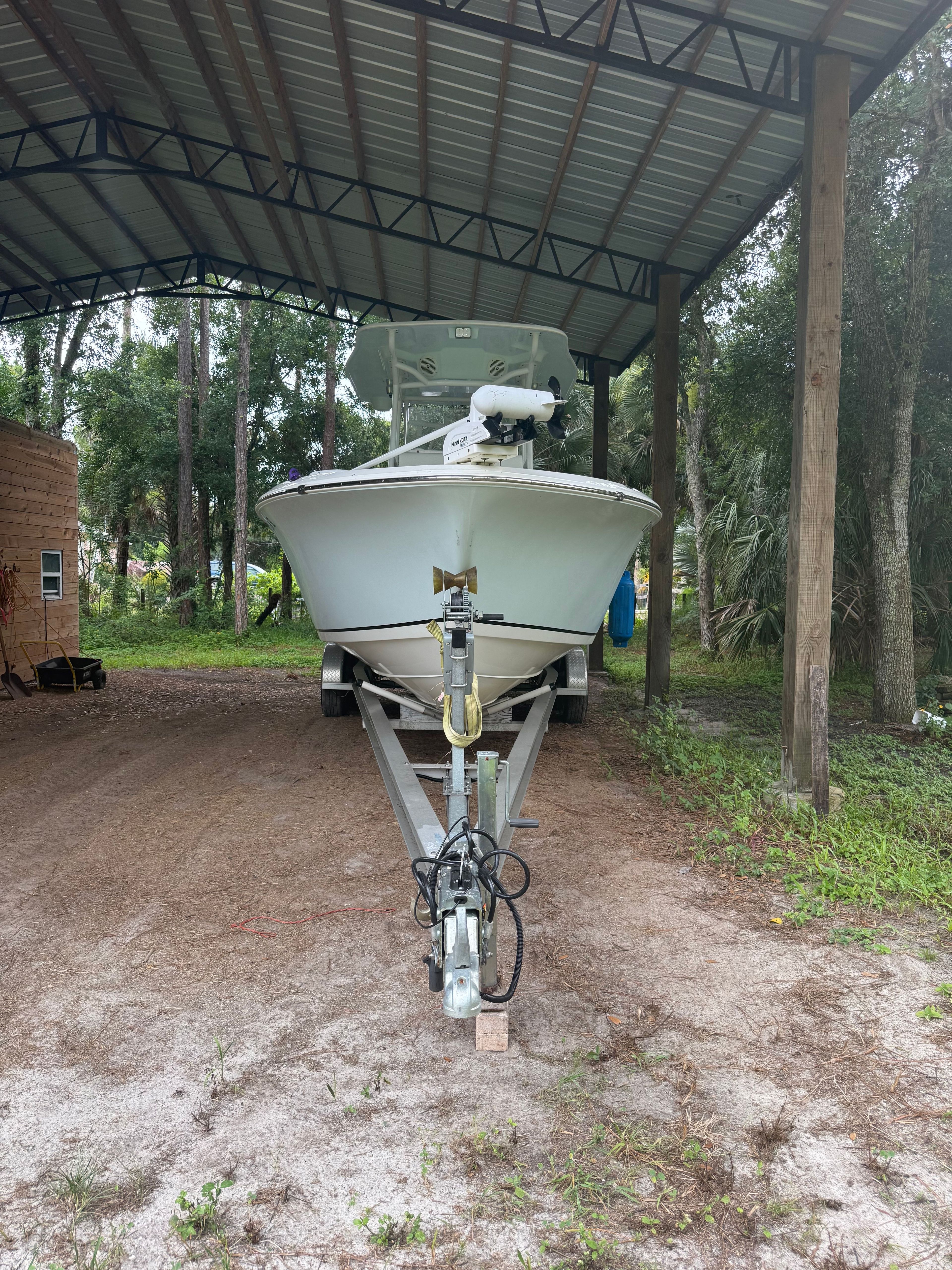 A 2021 Clearwater 2508 Center Console boat on a trailer under a covered area.