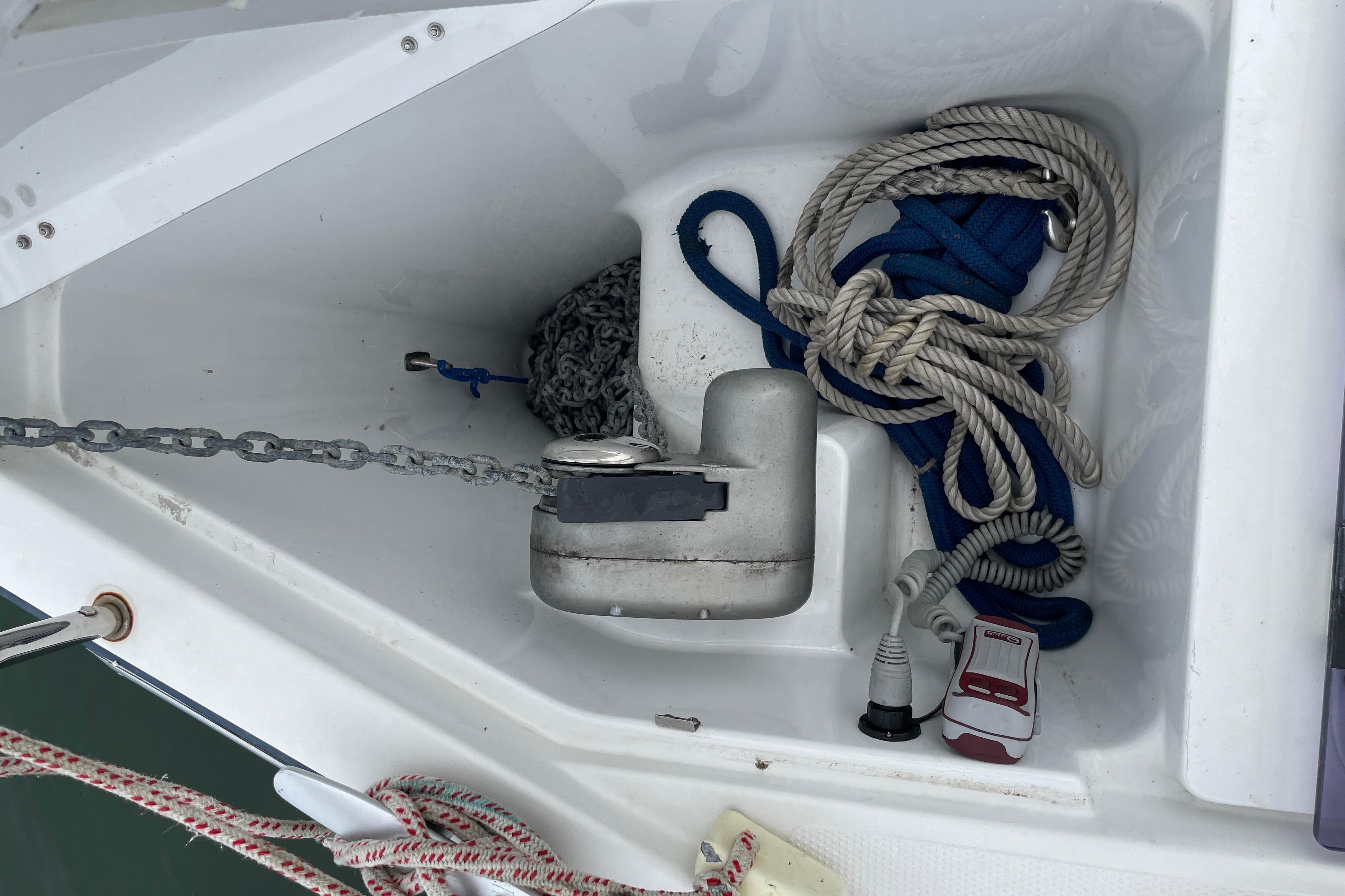 An anchor locker with chain and ropes on a boat.