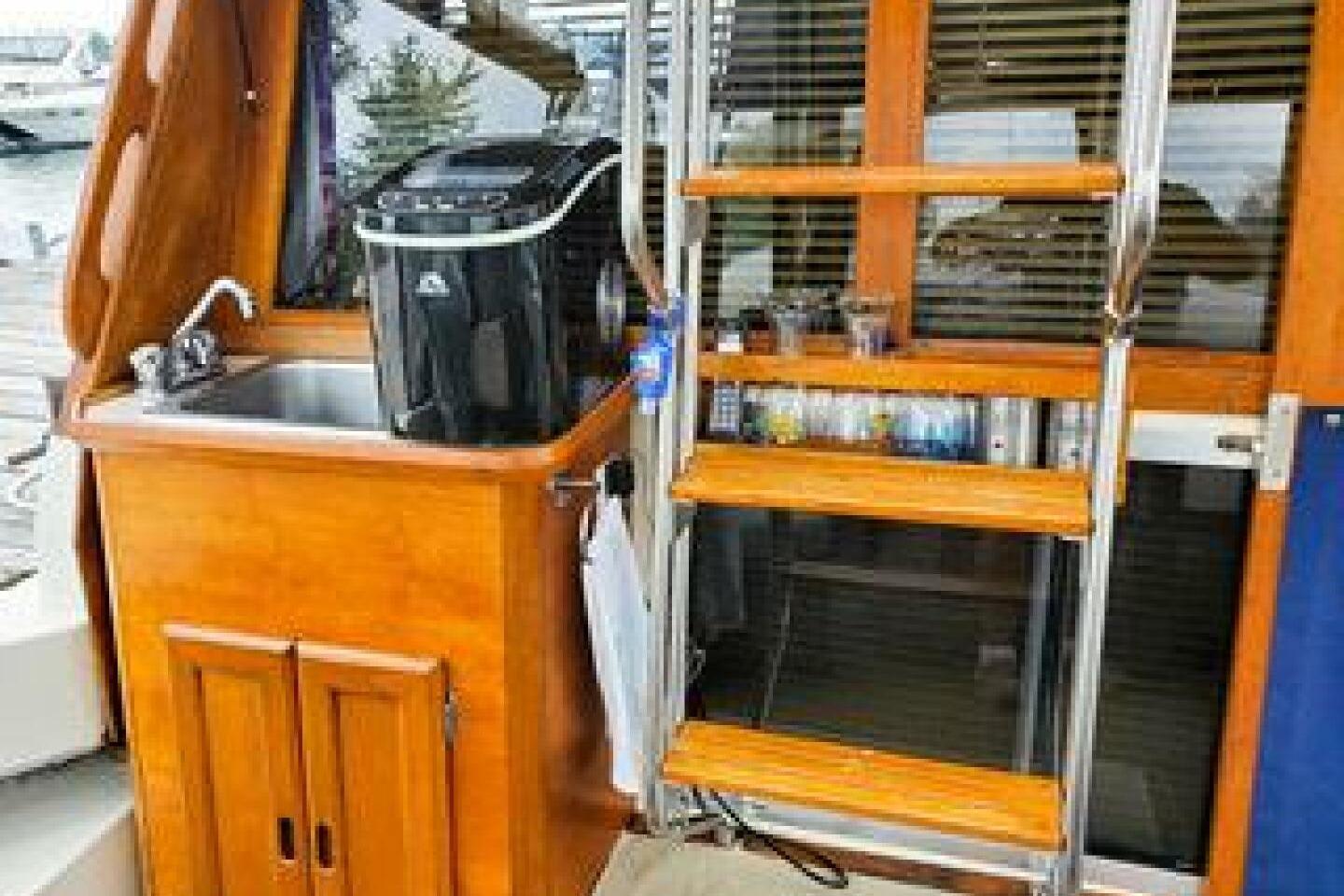 1986 Bayliner 3270 Motoryacht interior with sink, wooden cabinetry, and ladder.