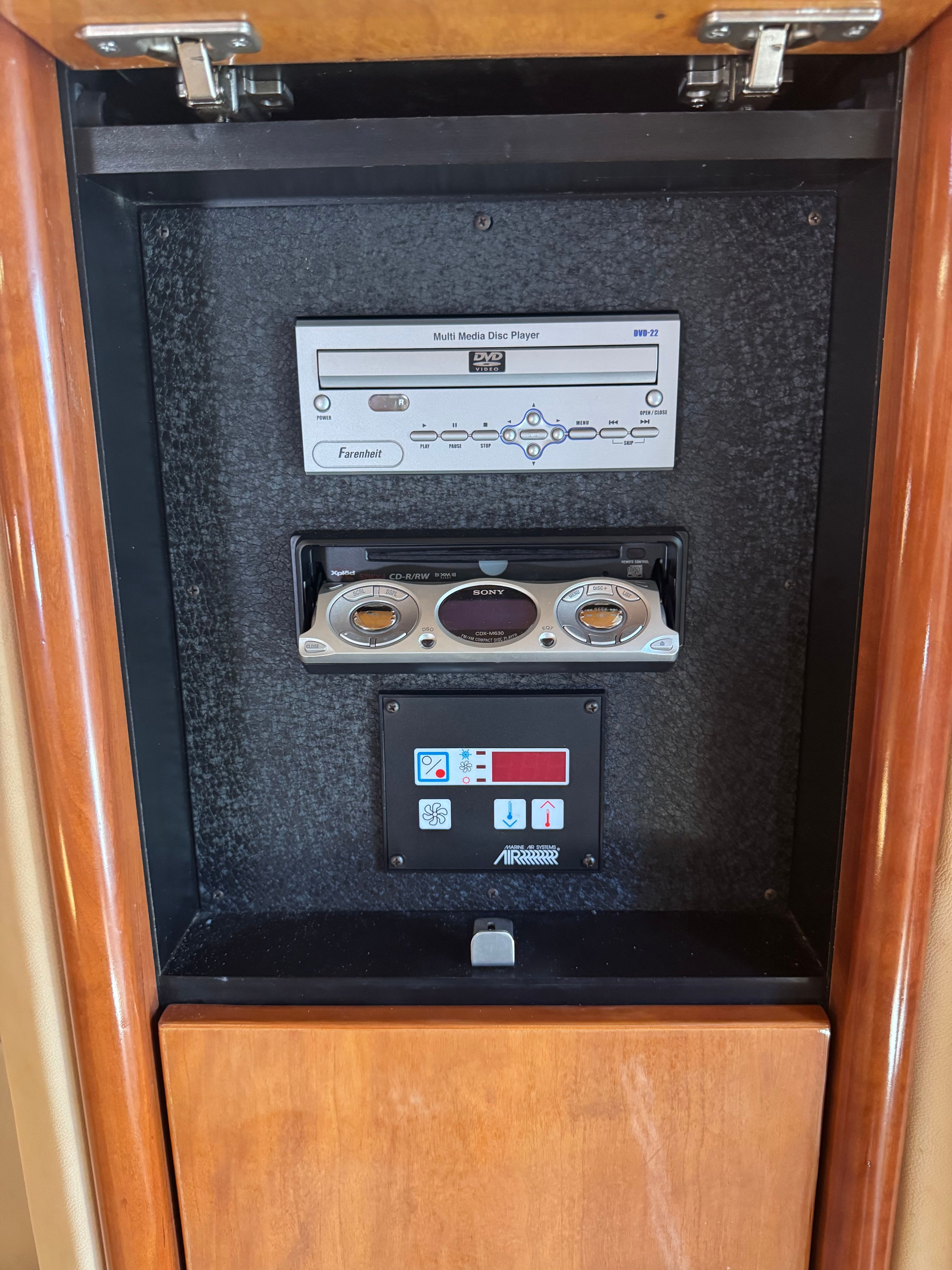 An audio system in a wooden cabinet with CD player and controls.