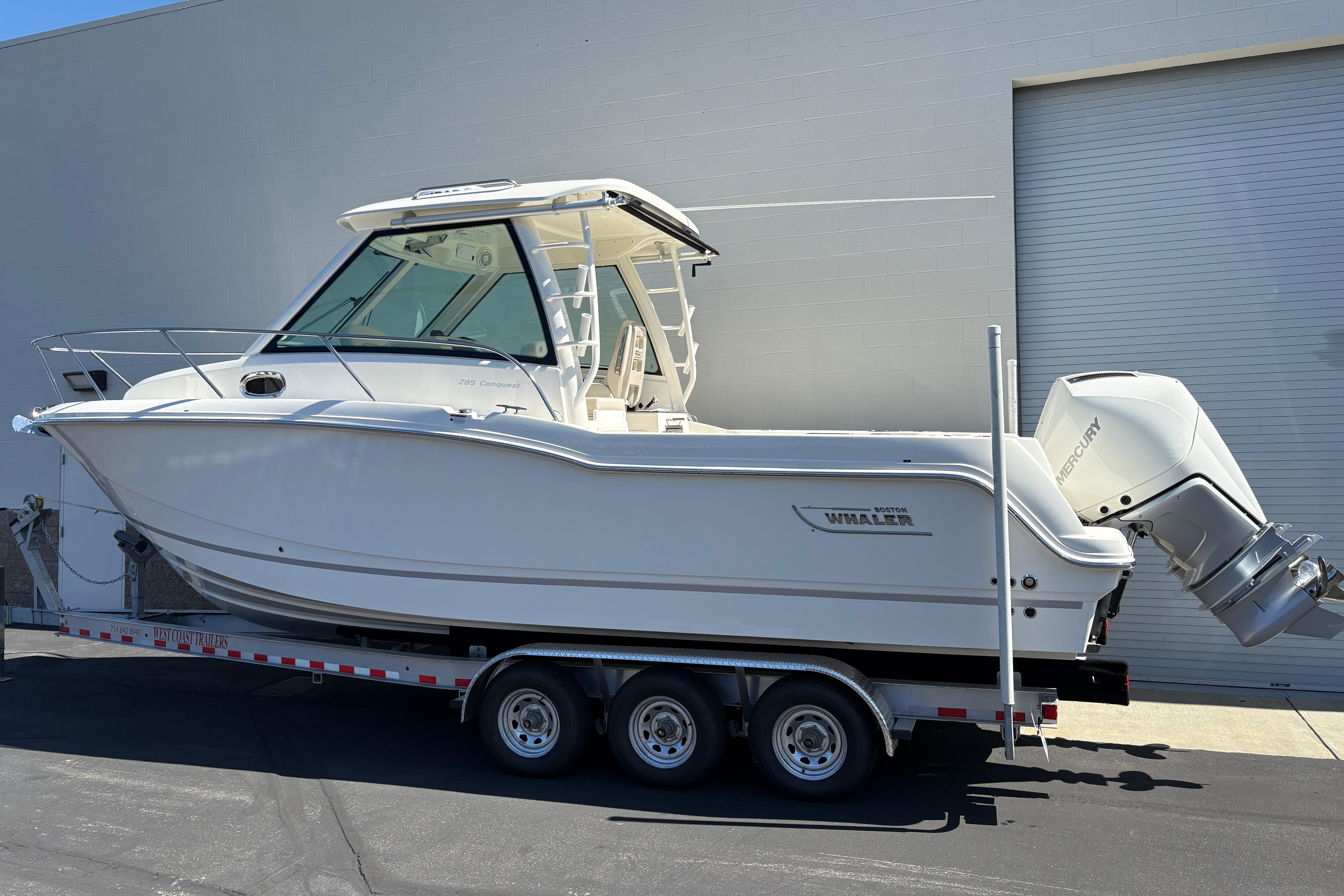 2026 Boston Whaler 285 Conquest boat on trailer, parked outdoors.