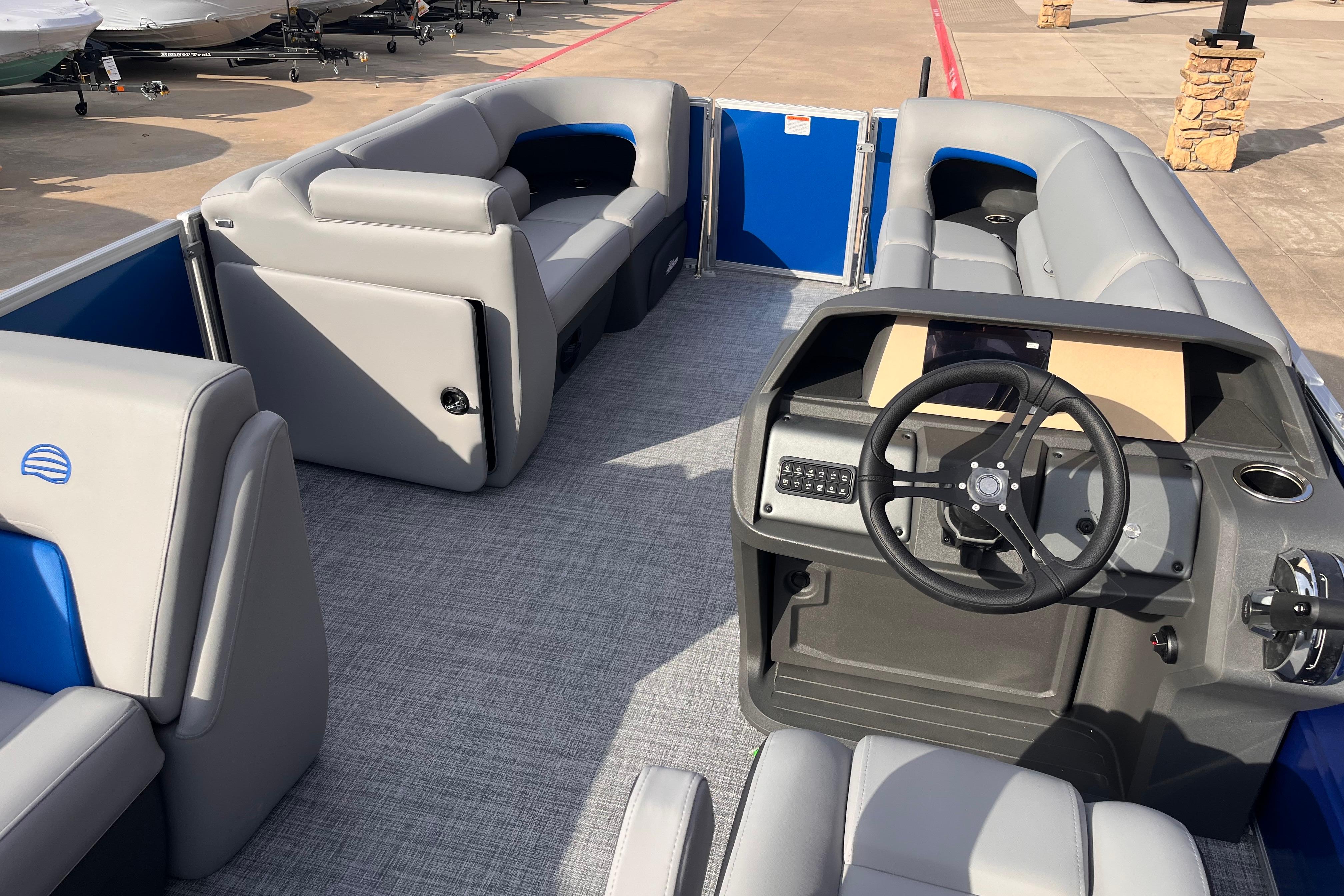 2026 Sun Tracker Party Barge 20 DLX interior with gray seating and steering console.