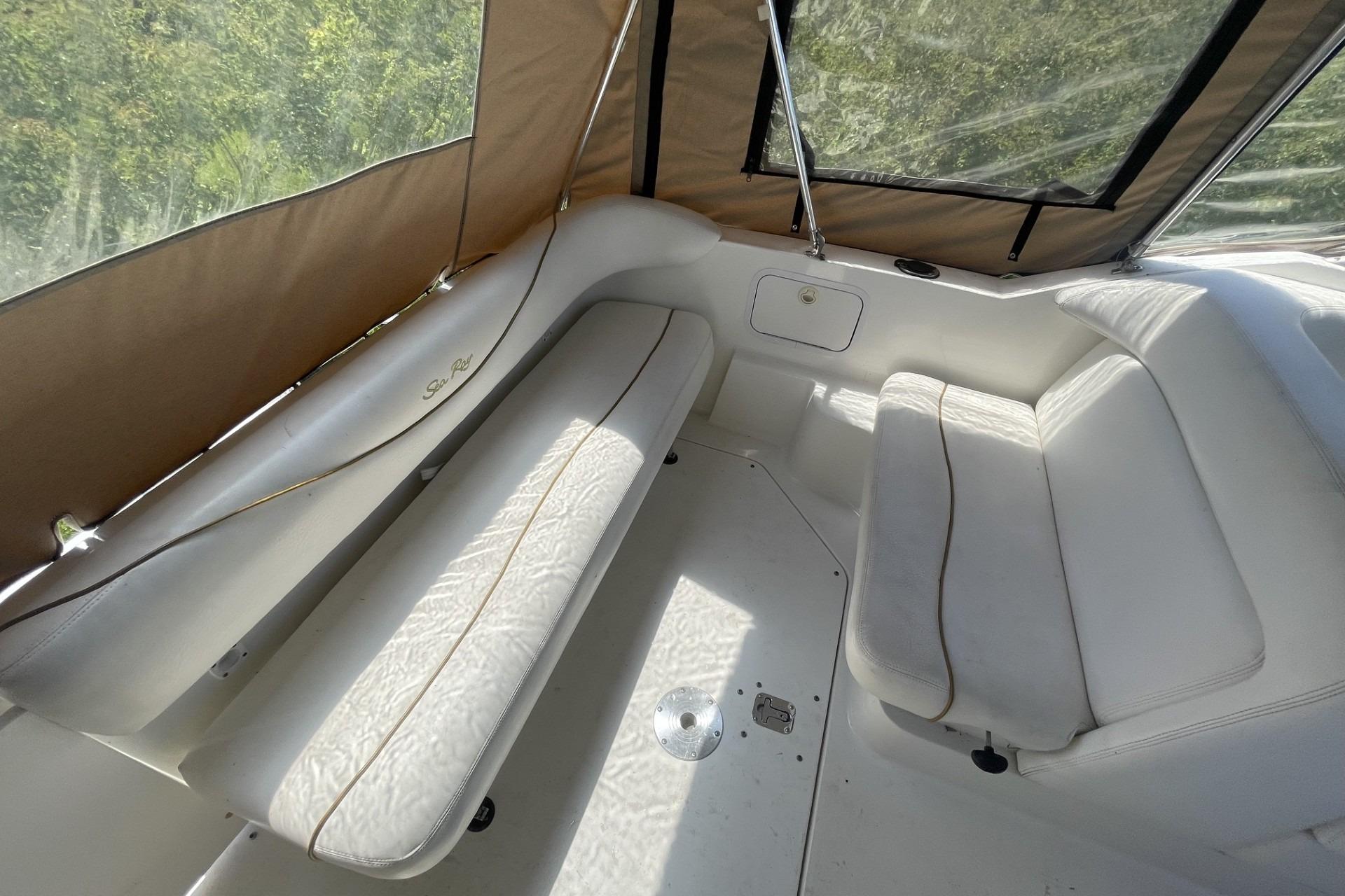 Interior seating of 2000 Sea Ray Sundancer 260 boat with beige upholstery and canopy.