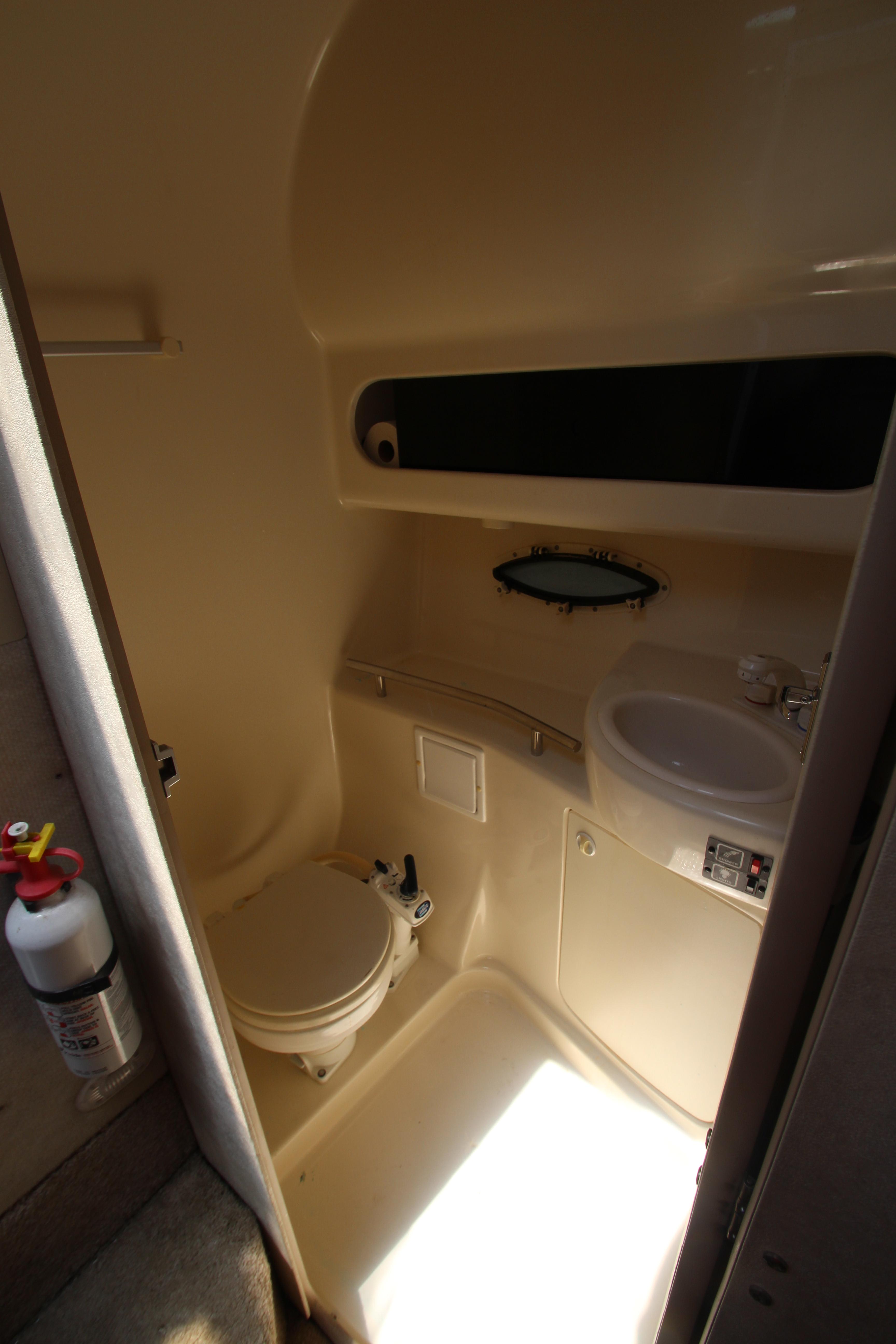 1999 Bayliner 3055 Ciera boat bathroom with toilet, sink, and storage.