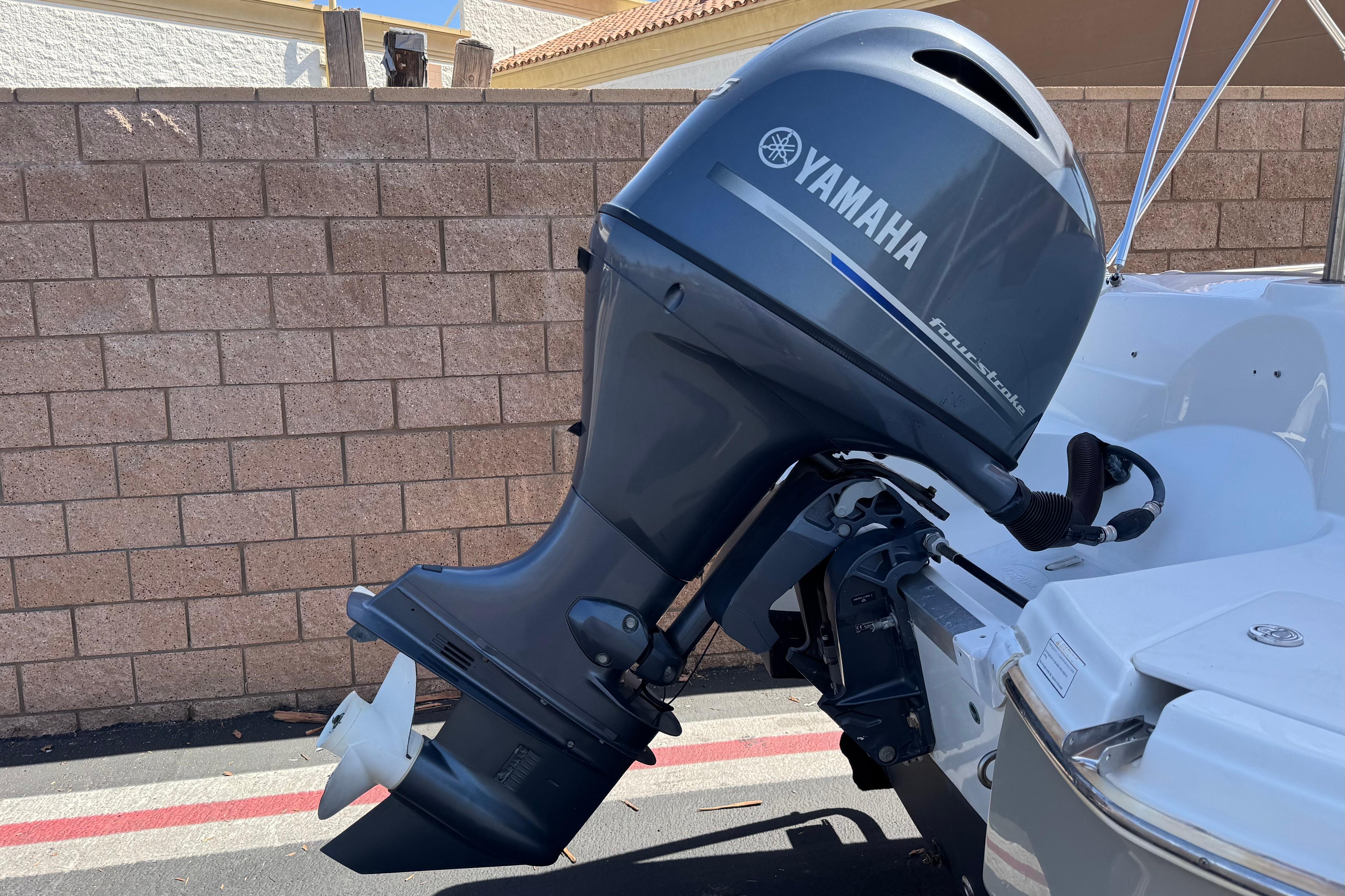 2020 NauticStar 203 SC boat with Yamaha outboard motor, parked near a brick wall.