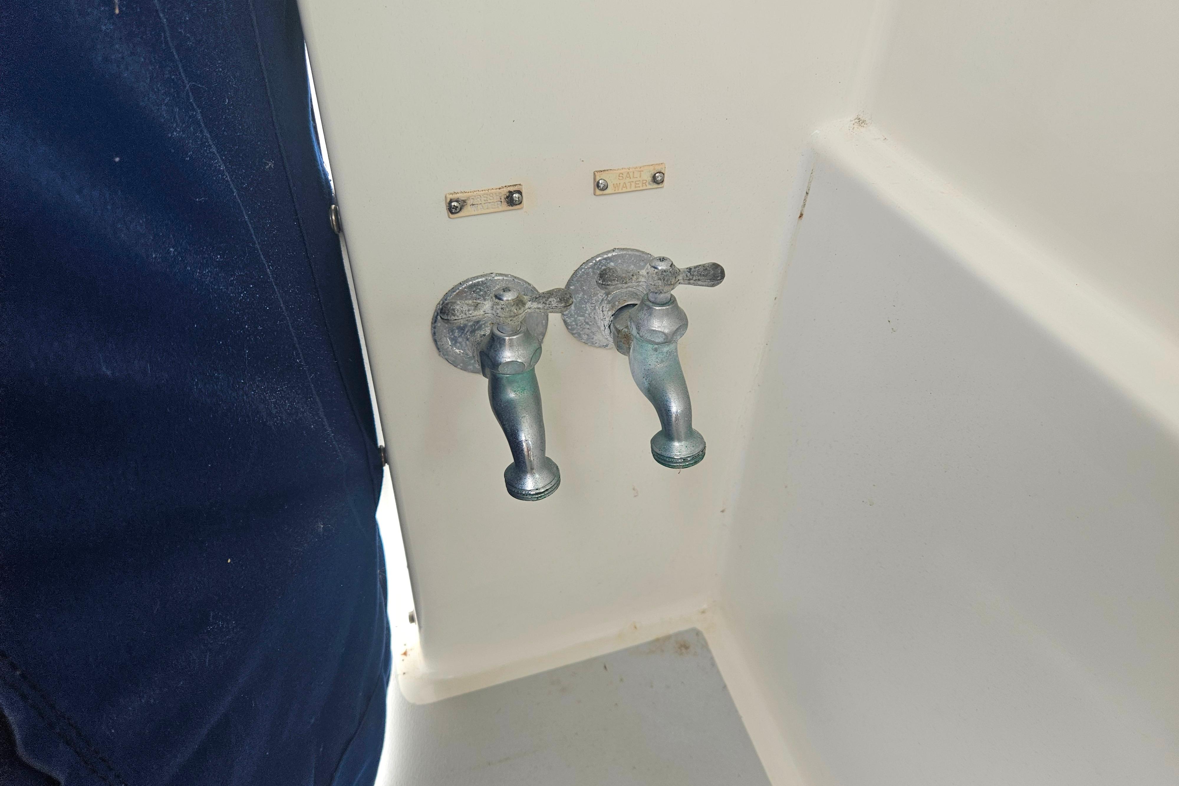 Two metal faucets on a 1999 Albin 28 Tournament Express boat interior.