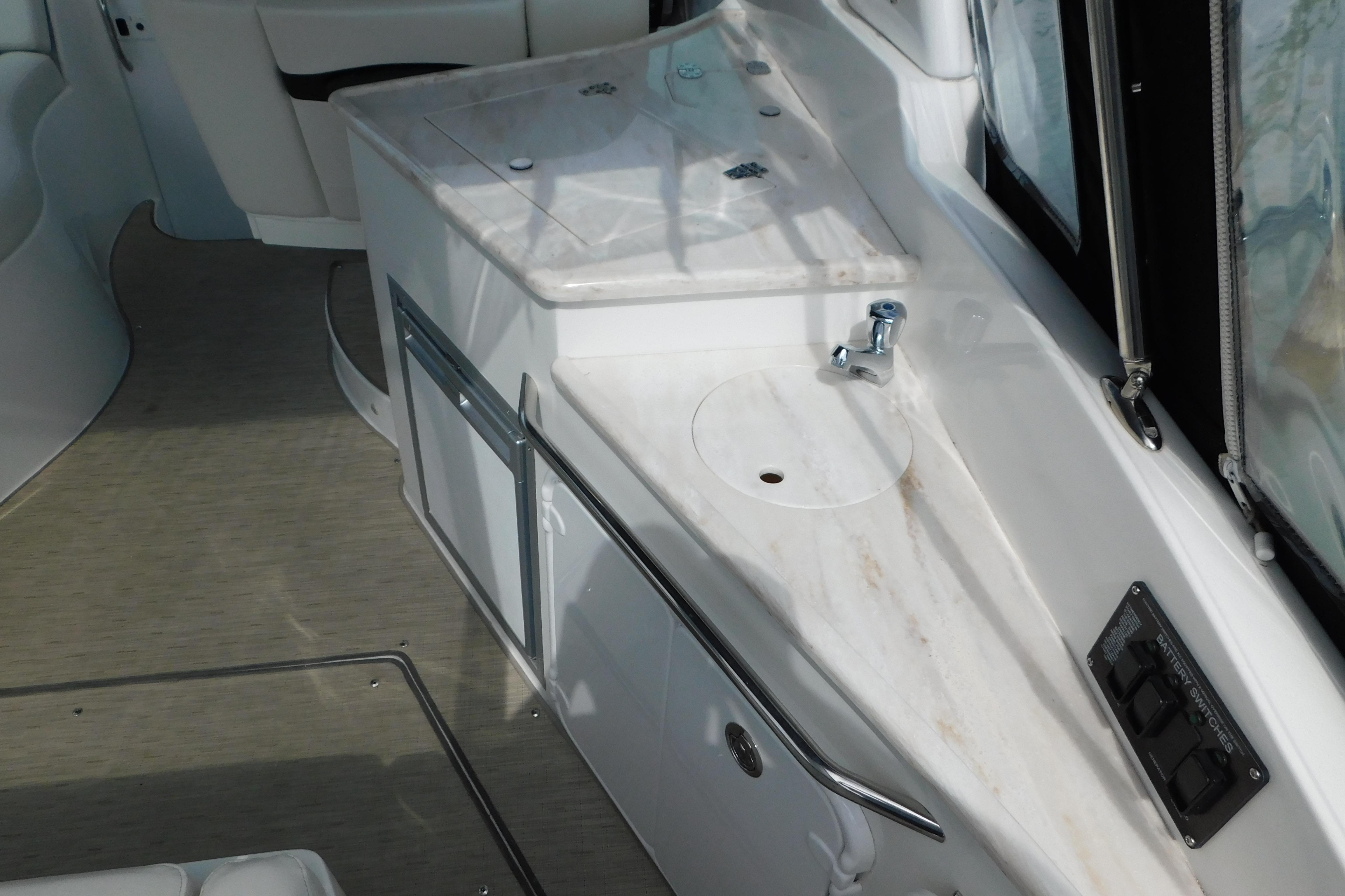 2017 Rinker EX 320 boat interior with sink and storage compartments.