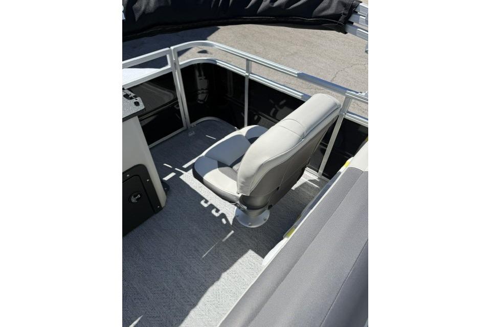 2026 Sun Tracker Fishin' Barge 20 DLX interior with gray seating and railing.