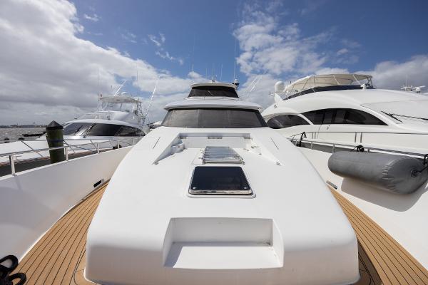 Grand Harbour 76 yacht, 2001 model, docked with other luxury boats under a partly cloudy sky.