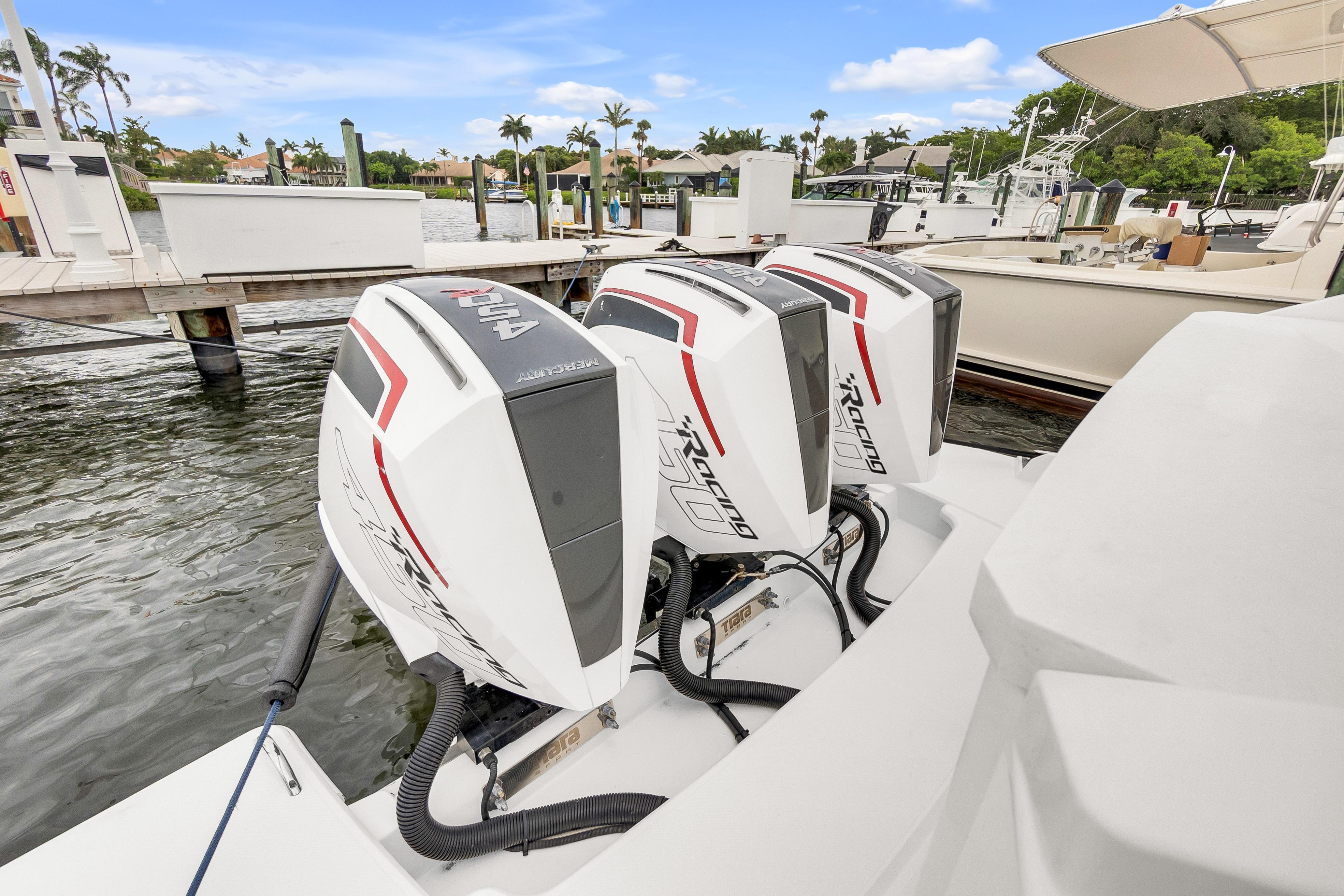 Triple Mercury Racing outboard engines on a 2021 Tiara Sport 43 LE boat at a marina.
