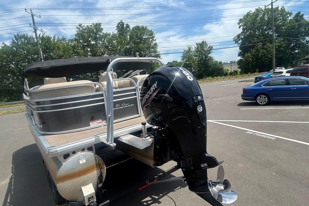 2023 Sun Tracker Party Barge 22 DLX pontoon boat with Mercury outboard motor in parking lot.