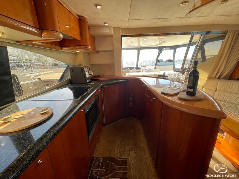 Luxurious 2001 Sunseeker Manhattan 74 yacht interior with elegant kitchen and dining area.