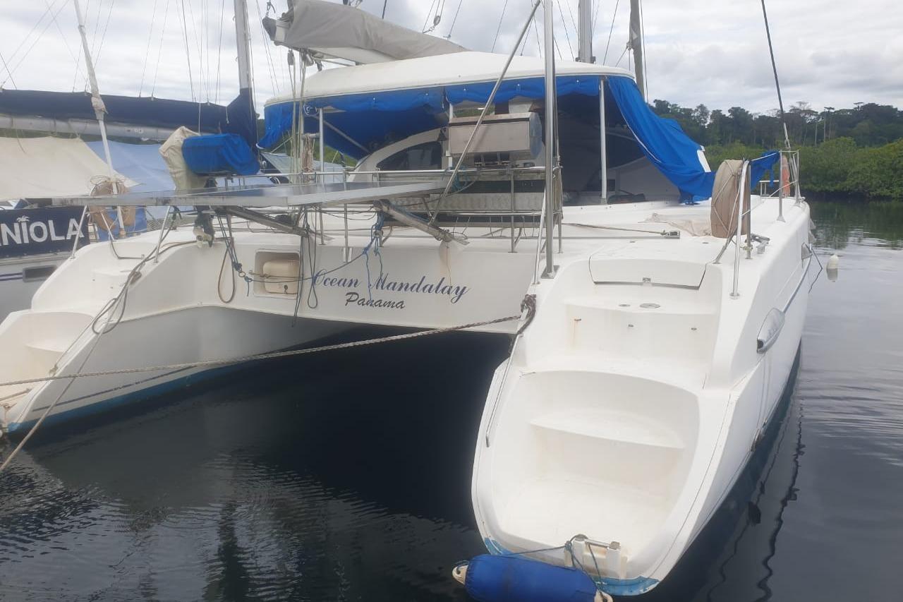 2003 Fountaine Pajot Belize 43 catamaran docked with blue canopy and white hull.