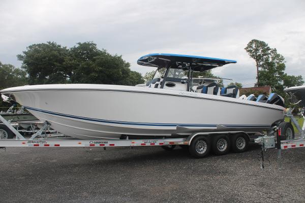 2024 Fountain 34 SC boat on trailer, white hull, blue accents, parked outdoors.