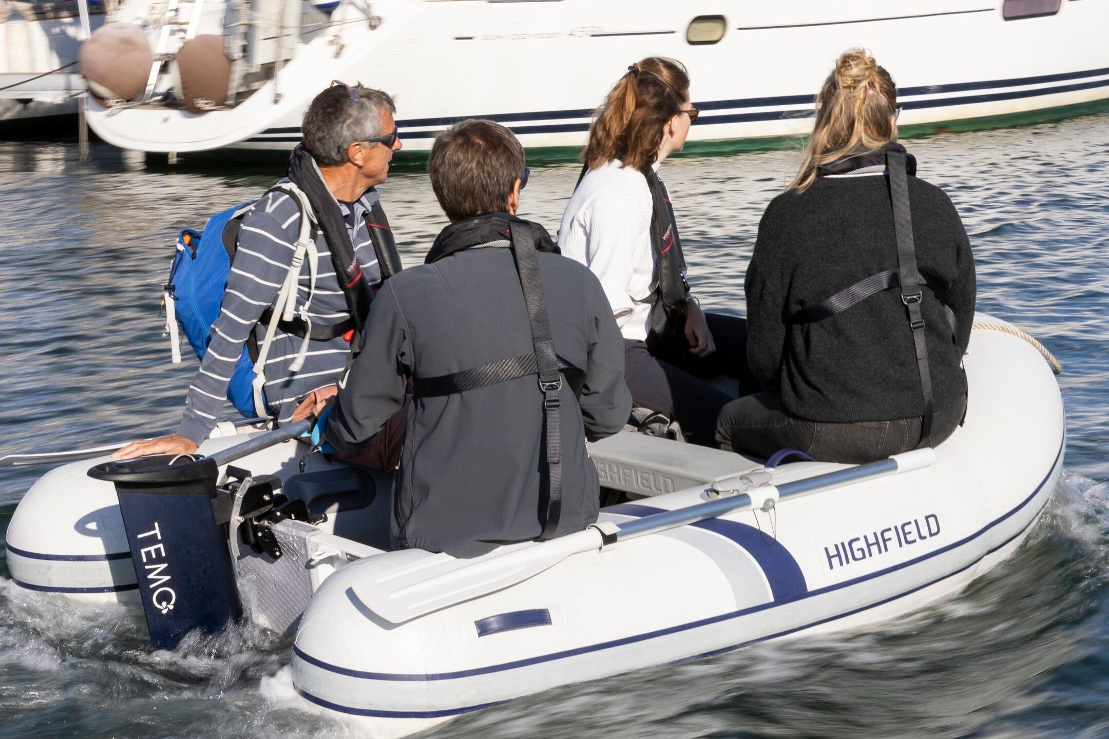 Four people on a Highfield Roll-Up 250 KAL inflatable boat, 2025 model.