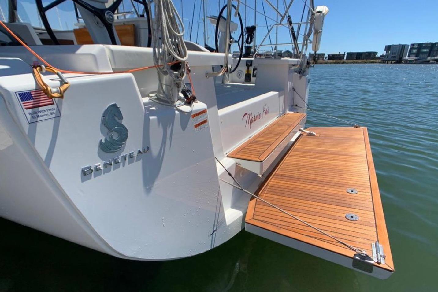 2020 Beneteau Oceanis 46.1 yacht with teak swim platform, docked in sunny marina.
