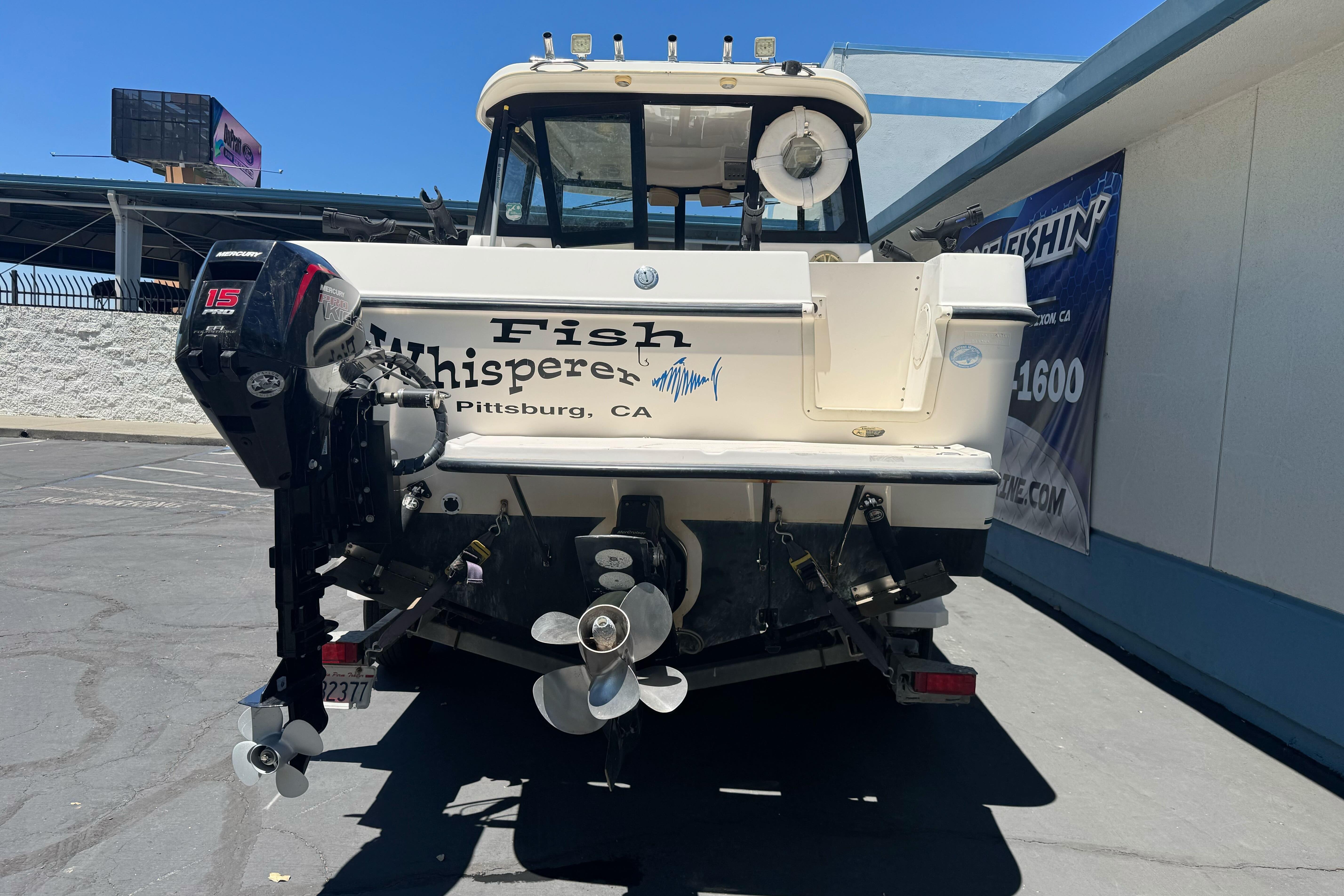 2004 Trophy 2359 WA boat with "Fish Whisperer" text, parked outdoors in Pittsburg, CA.