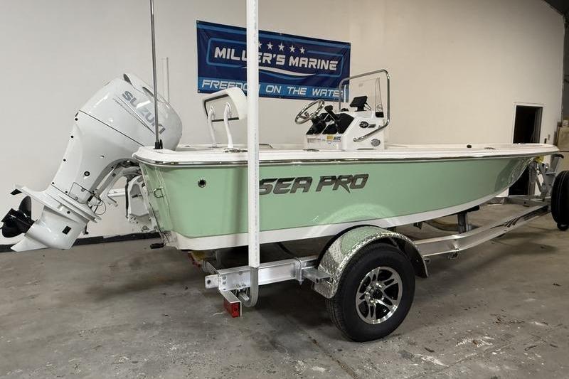 2026 Sea Pro 172 Bay boat on trailer in showroom, featuring Suzuki outboard motor.