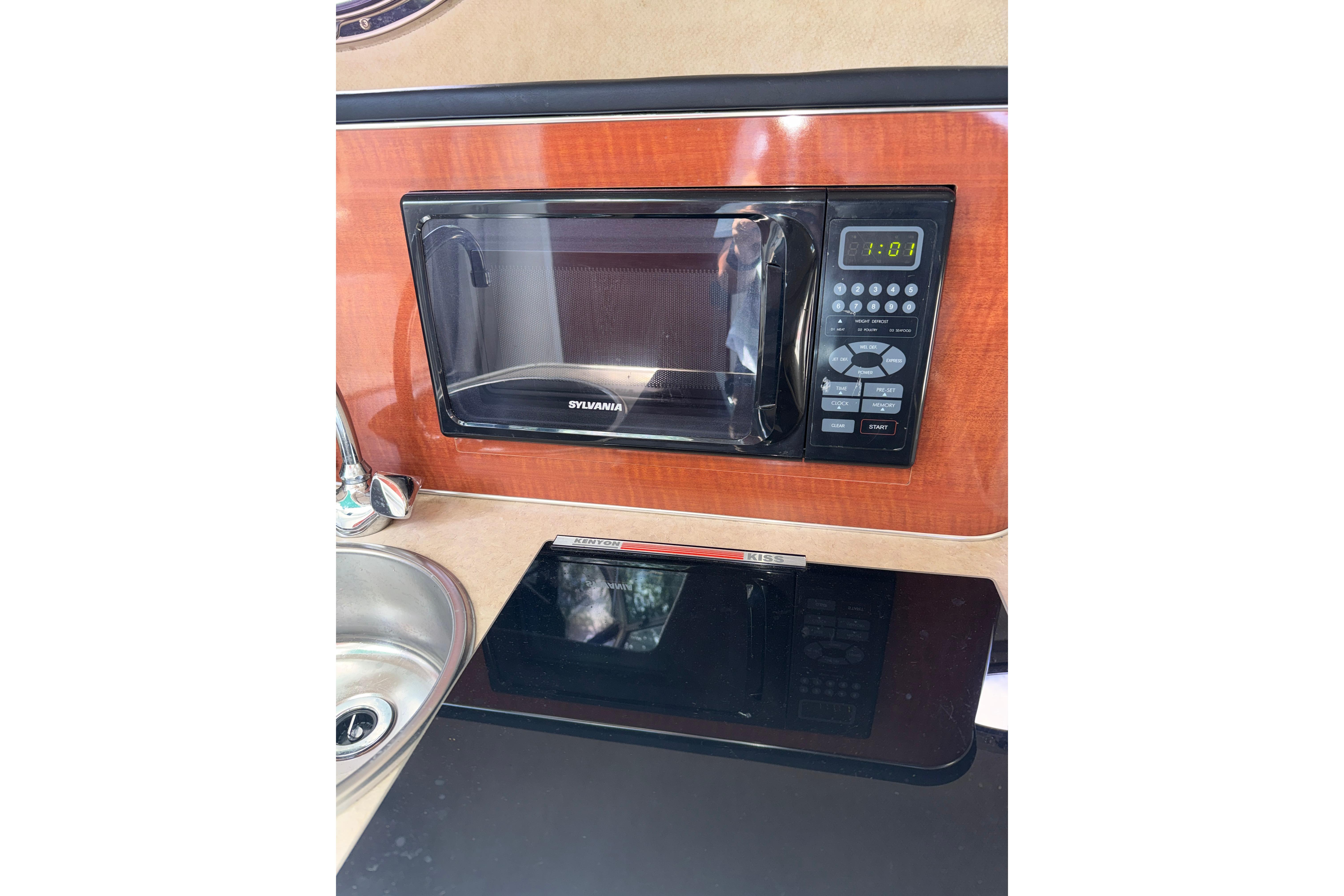 Microwave and sink in 2004 Sea Ray 240 Sundancer boat kitchen area.