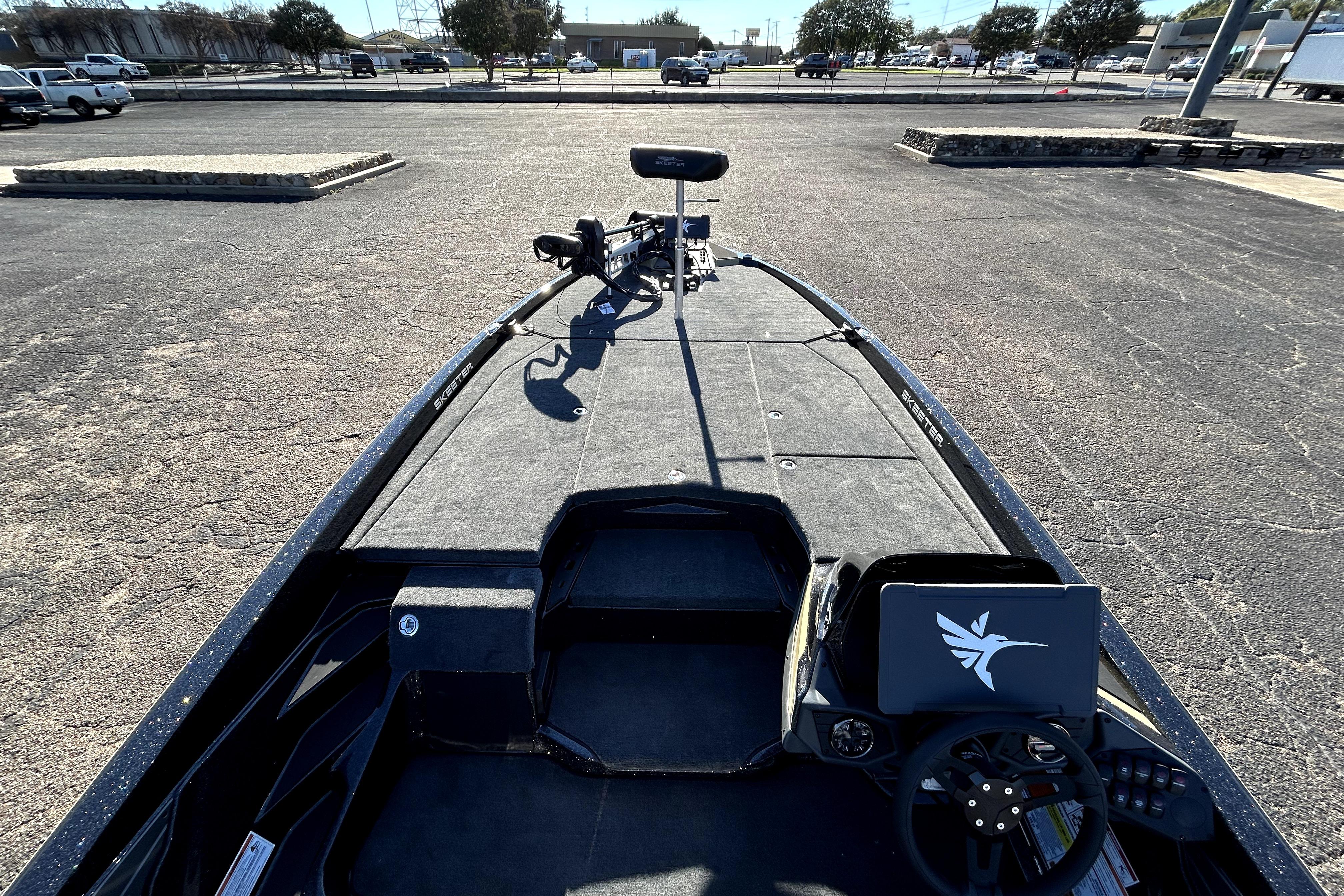 2026 Skeeter ZXE21 fishing boat in a parking lot, showcasing deck and steering console.