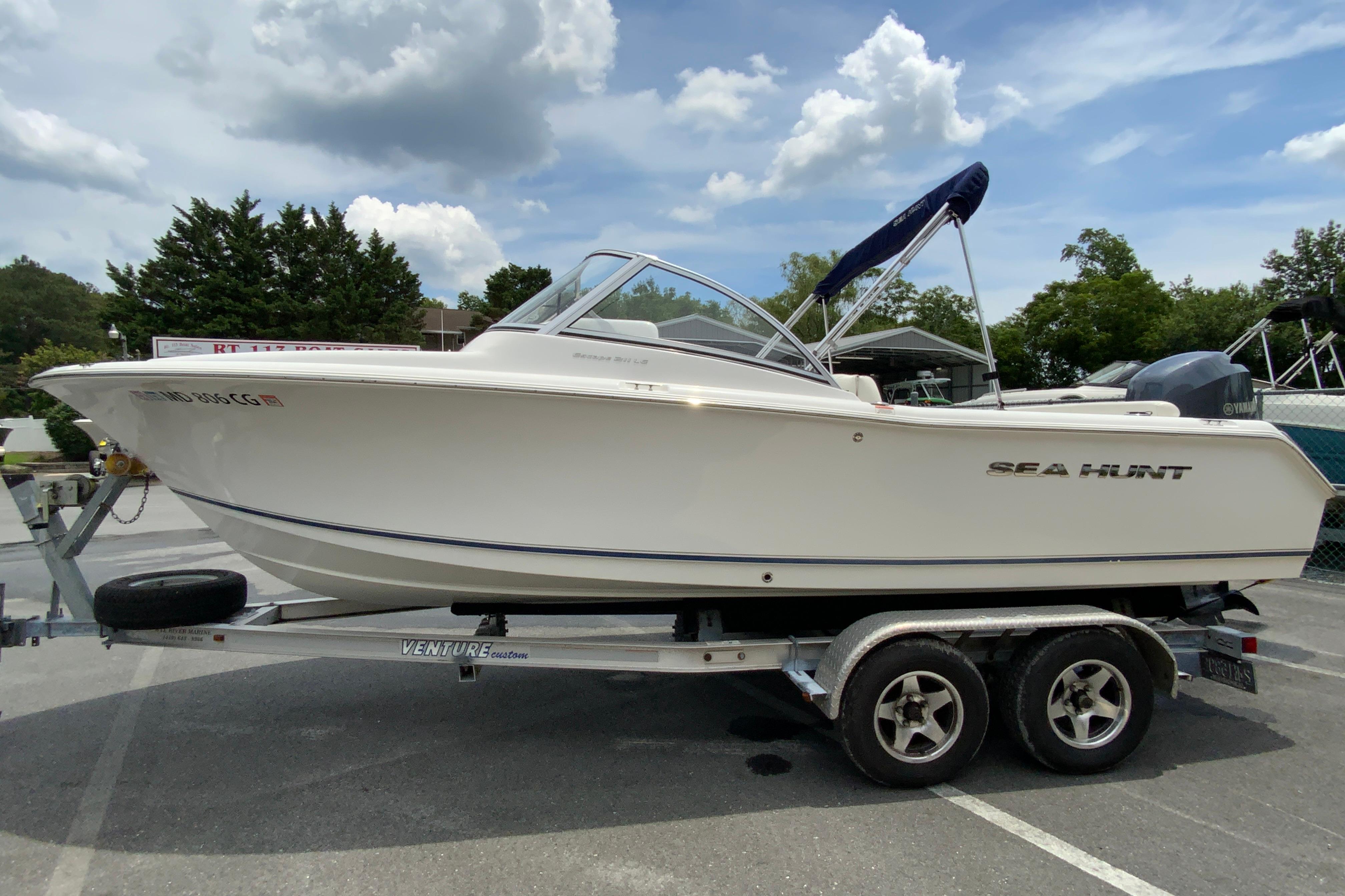 2014 Sea Hunt Escape 211 LE boat on trailer under a cloudy sky.