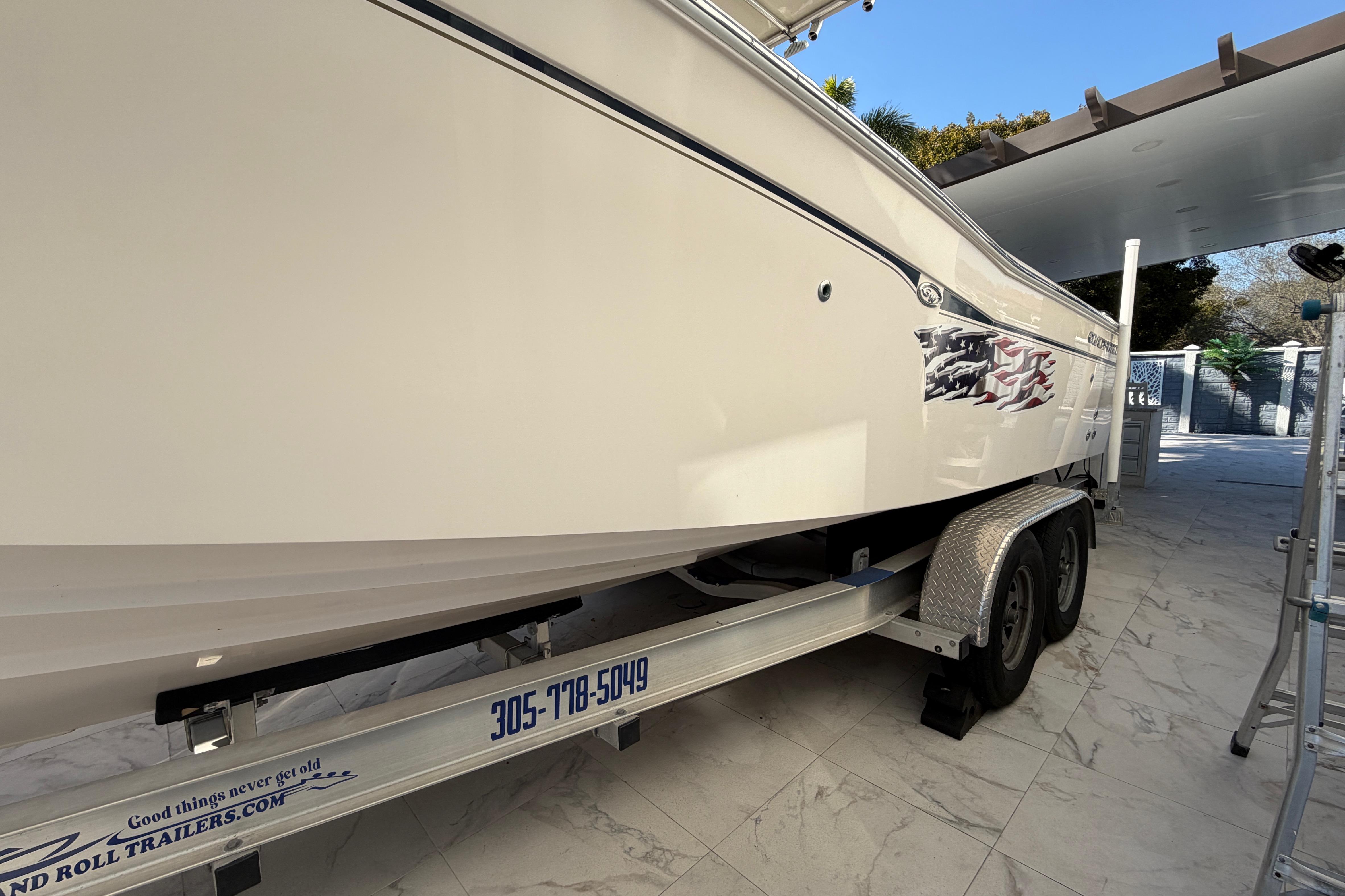 2004 Grady White 273 boat on trailer, parked in a tiled driveway.