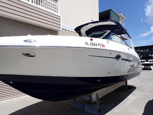 2011 Chaparral 287 SSX boat on display, white and blue exterior, docked outdoors.
