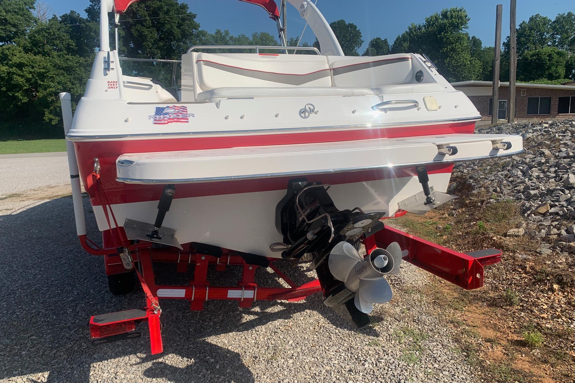 2006 Rinker 282 Captiva Cuddy boat, red and white, rear view with propeller.