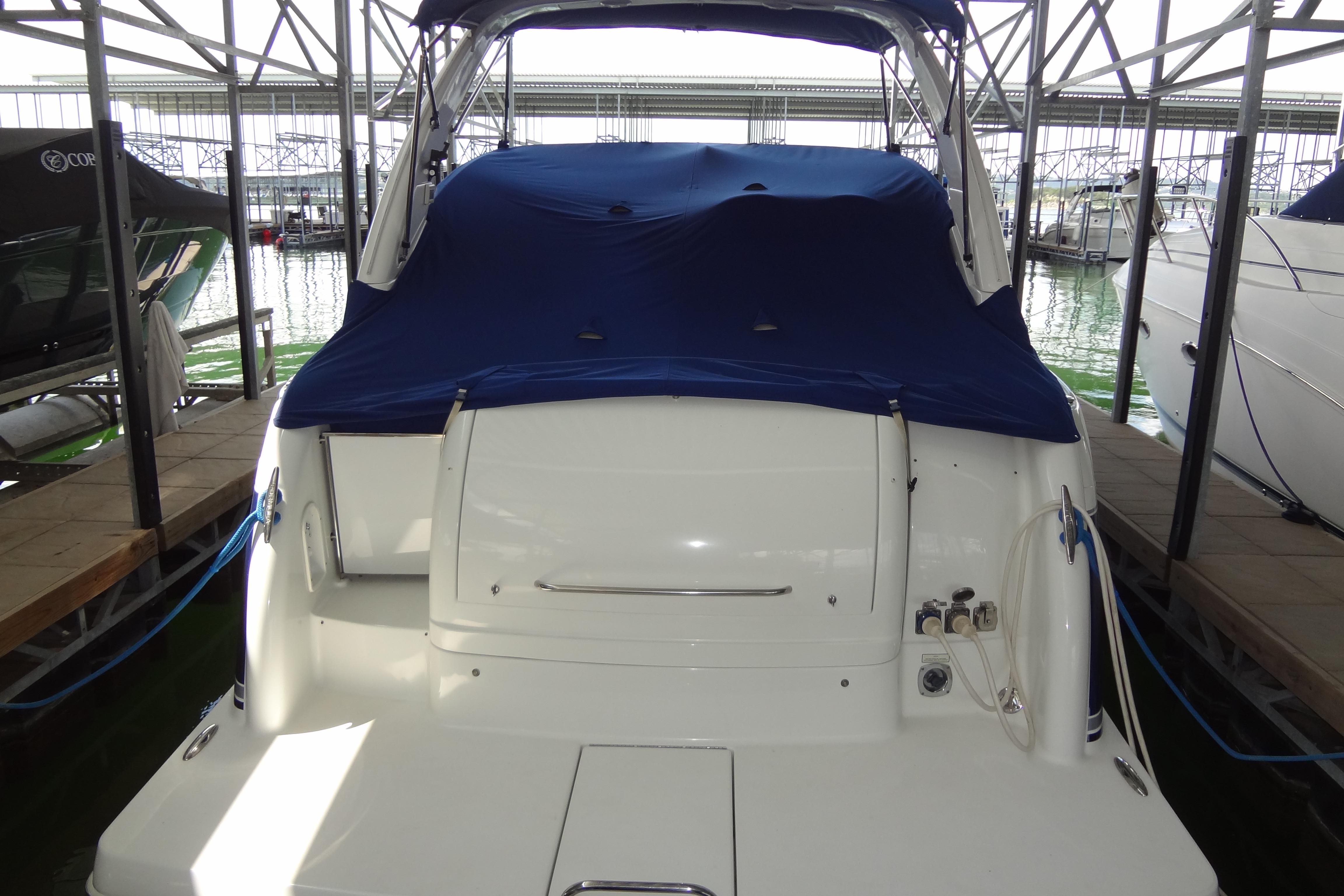 2007 Formula 34 Performance Cruiser docked, covered with blue tarp, in marina setting.