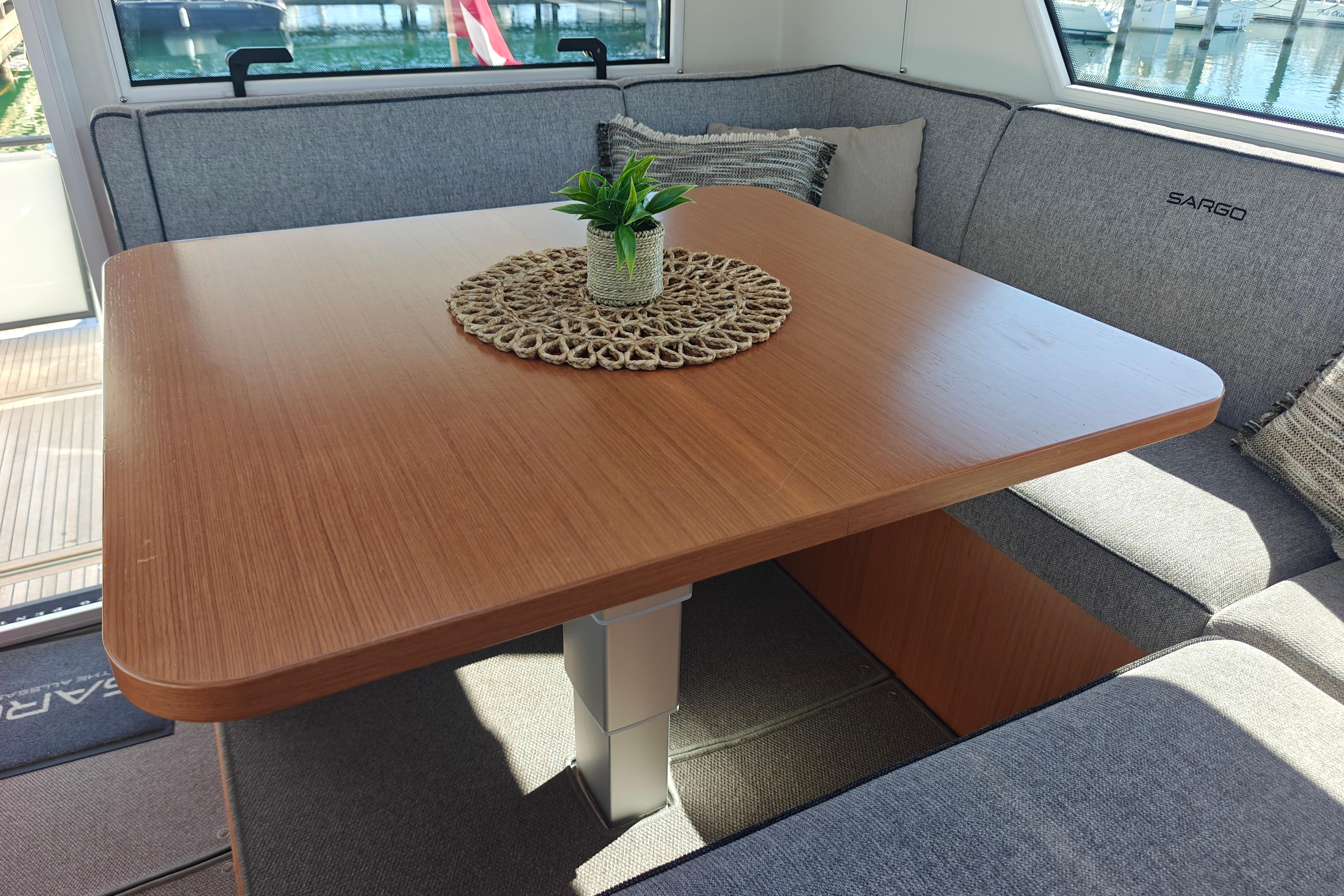 Interior of 2024 Sargo 45 Explorer with wooden table and gray seating.